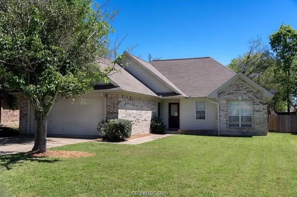 A single-story house with a brick and white siding exterior, a gray roof, and a green lawn under a blue sky.