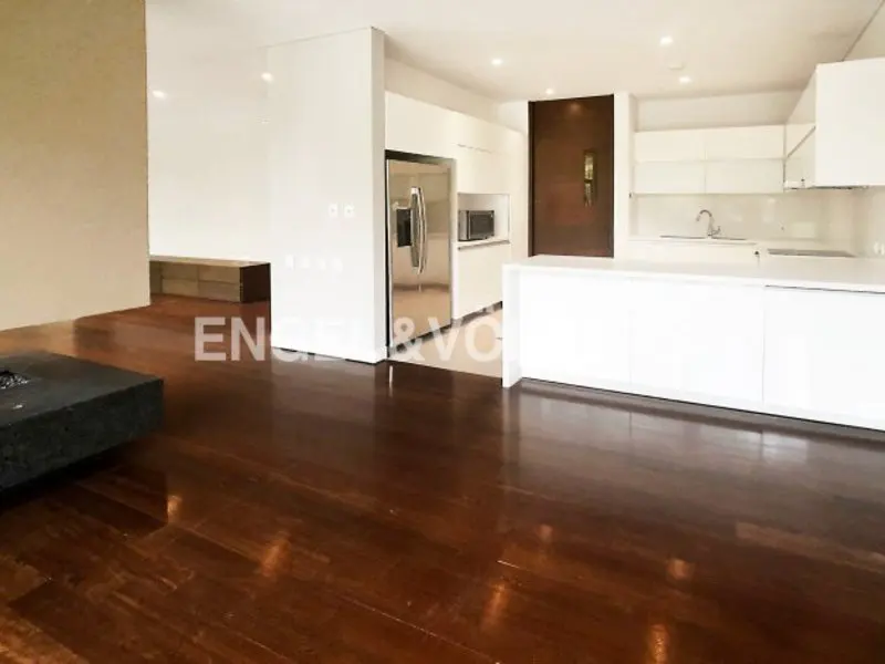 Open-concept living space with dark wood floors, white kitchen cabinets, and stainless steel appliances.