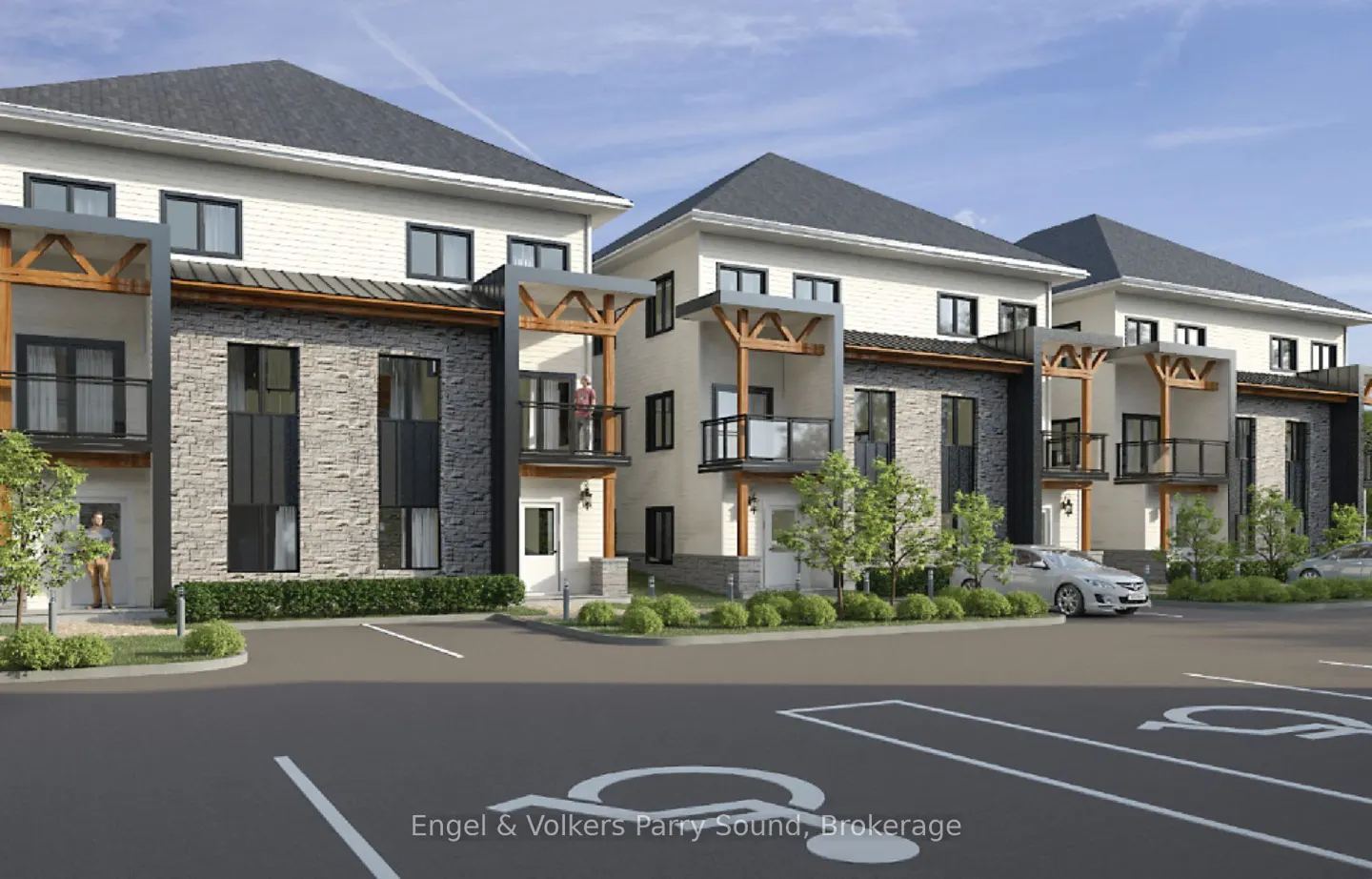 Modern townhouses with stone and white siding, wooden balconies, and a parking lot with accessible spaces in the foreground.