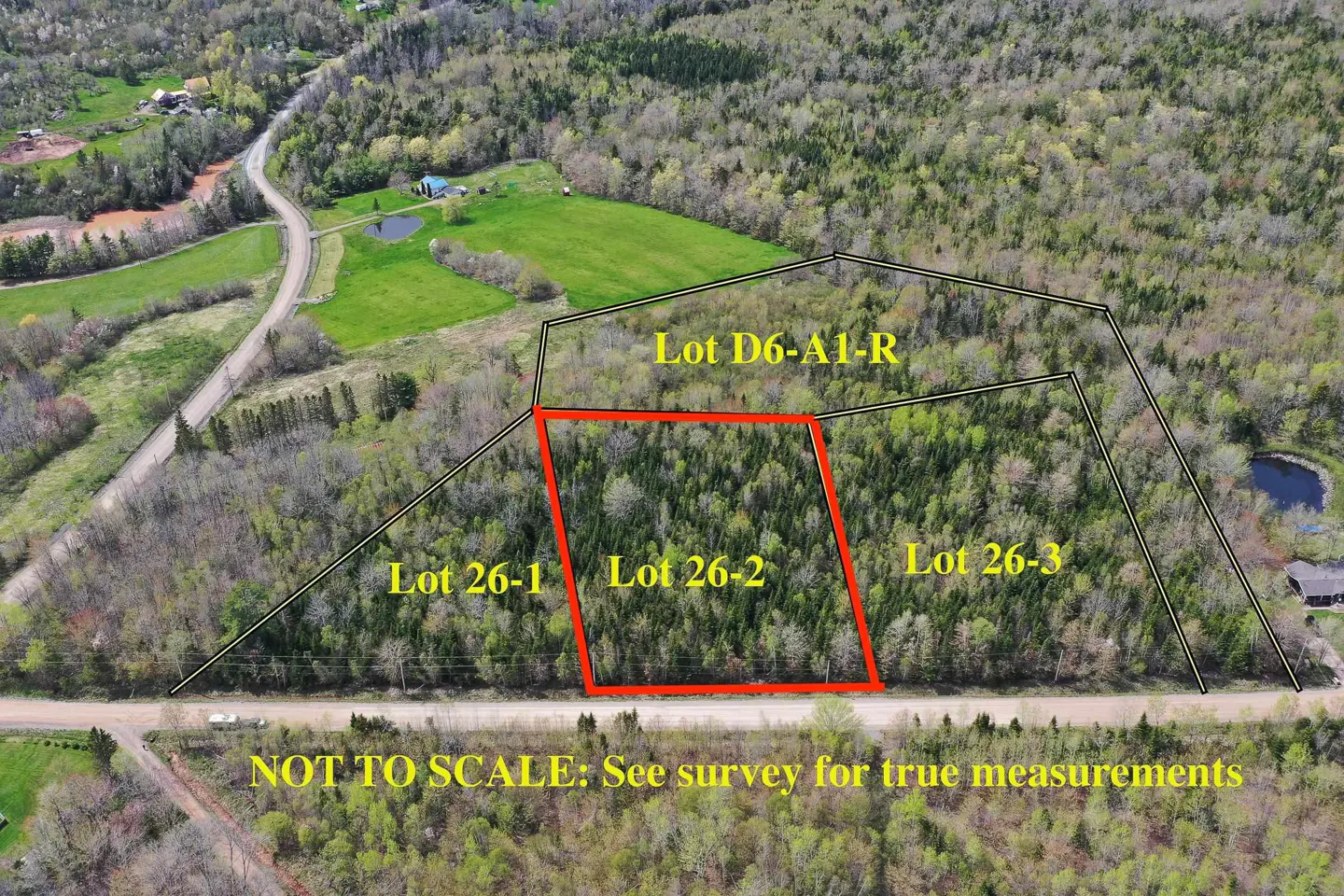 Aerial view of wooded land lots, with Lot 26-2 outlined in red. Other lots are labeled, and a road runs along the bottom.