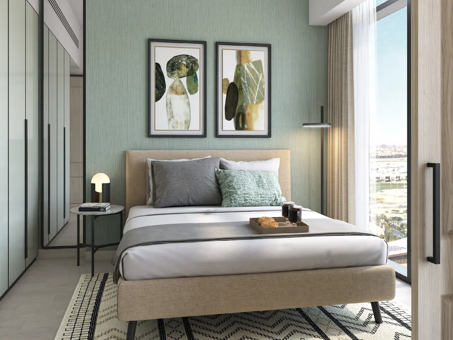Bedroom with a tan bed, gray and green pillows, and a tray with food. Two framed abstract art pieces hang above the bed. A black and white rug is on the floor.