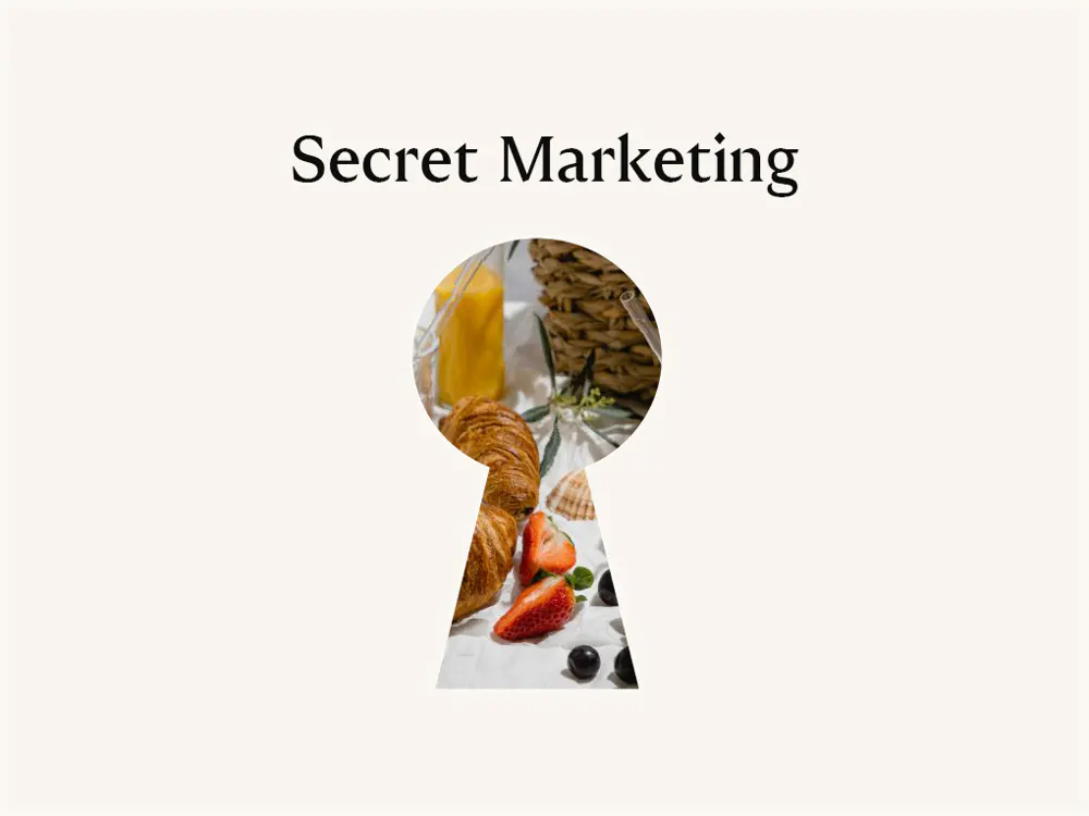 "Secret Marketing" text above a keyhole view of croissants, strawberries, juice, and a basket.