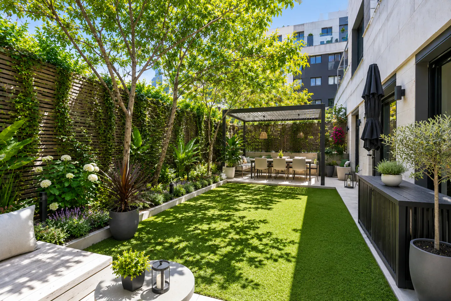 A backyard with green grass, a dining table under a pergola, and a wooden fence covered in vines.