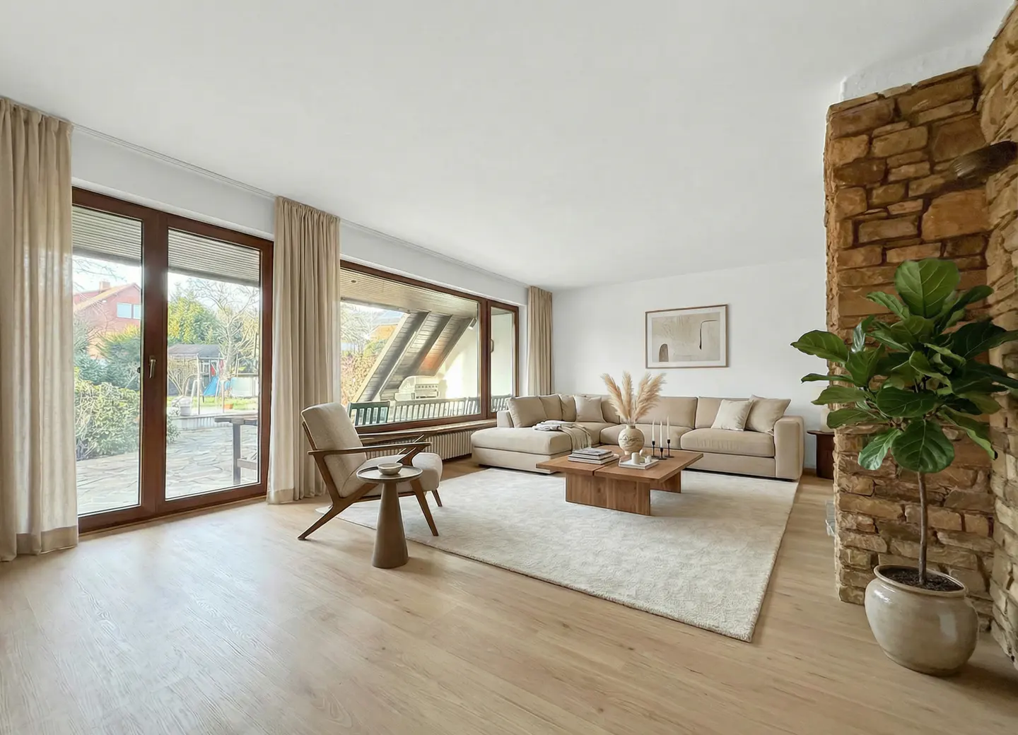 Bright living room with beige sectional sofa, wood coffee table, and stone accent wall with a potted fiddle-leaf fig tree. Large windows with curtains.