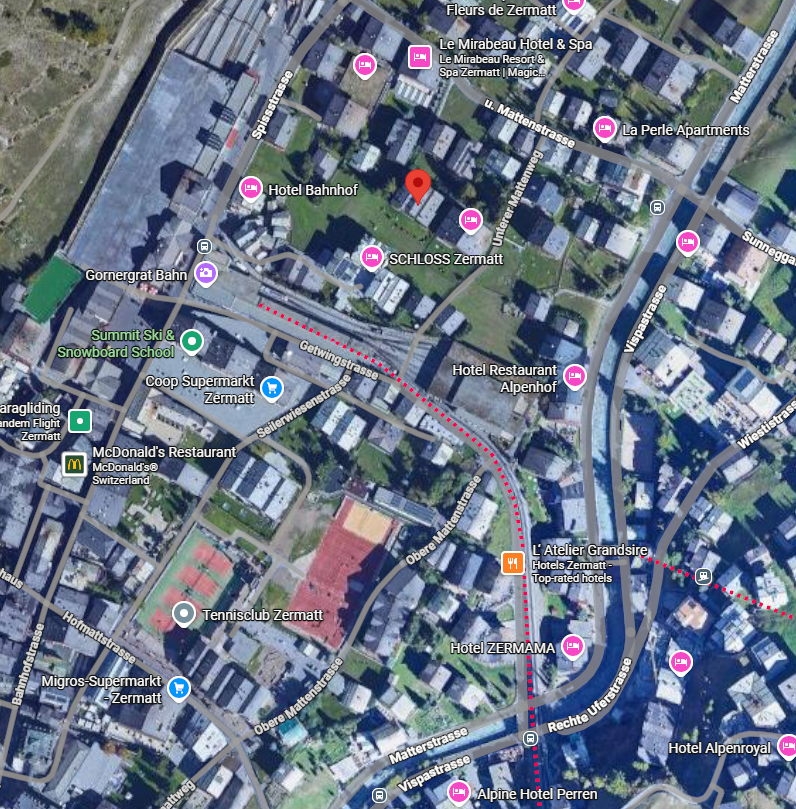 Aerial view of Zermatt, Switzerland, with hotels, restaurants, supermarkets, and tennis courts.