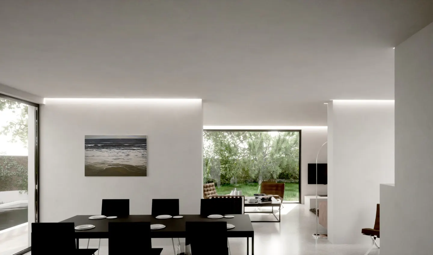 Bright, modern dining and living room with white walls and black furniture. A beach painting hangs above the dining table. Large windows overlook a green yard.