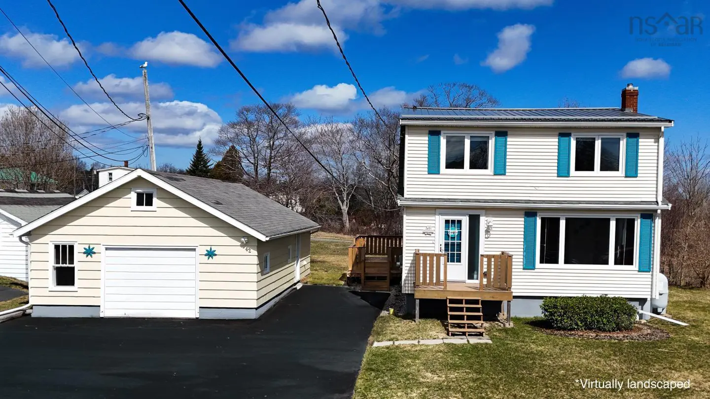 Two-story white house with blue shutters and a detached garage on a sunny day.