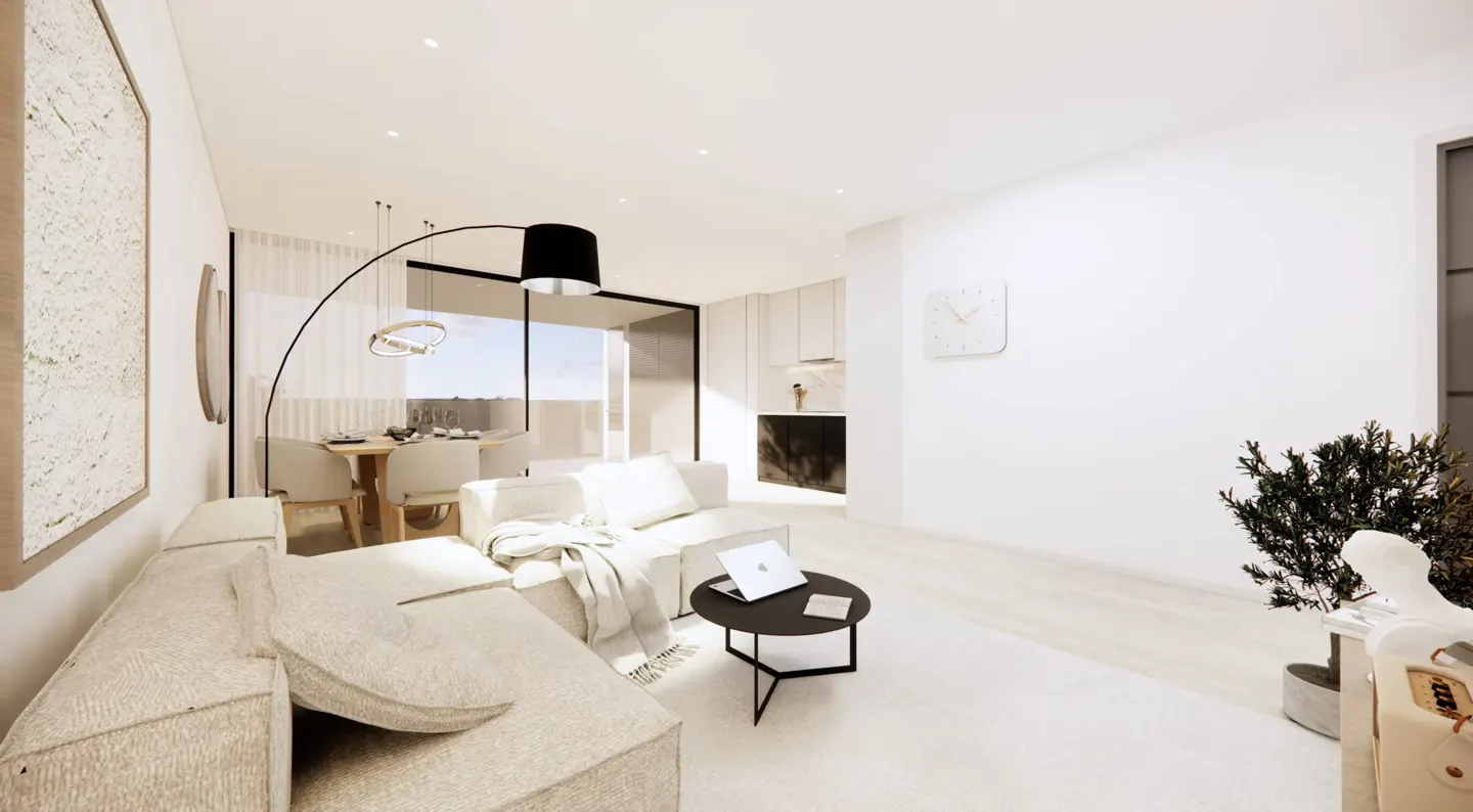 Bright, modern living room with beige sofa, black coffee table with laptop, dining area, and white walls. A black arched floor lamp adds style.