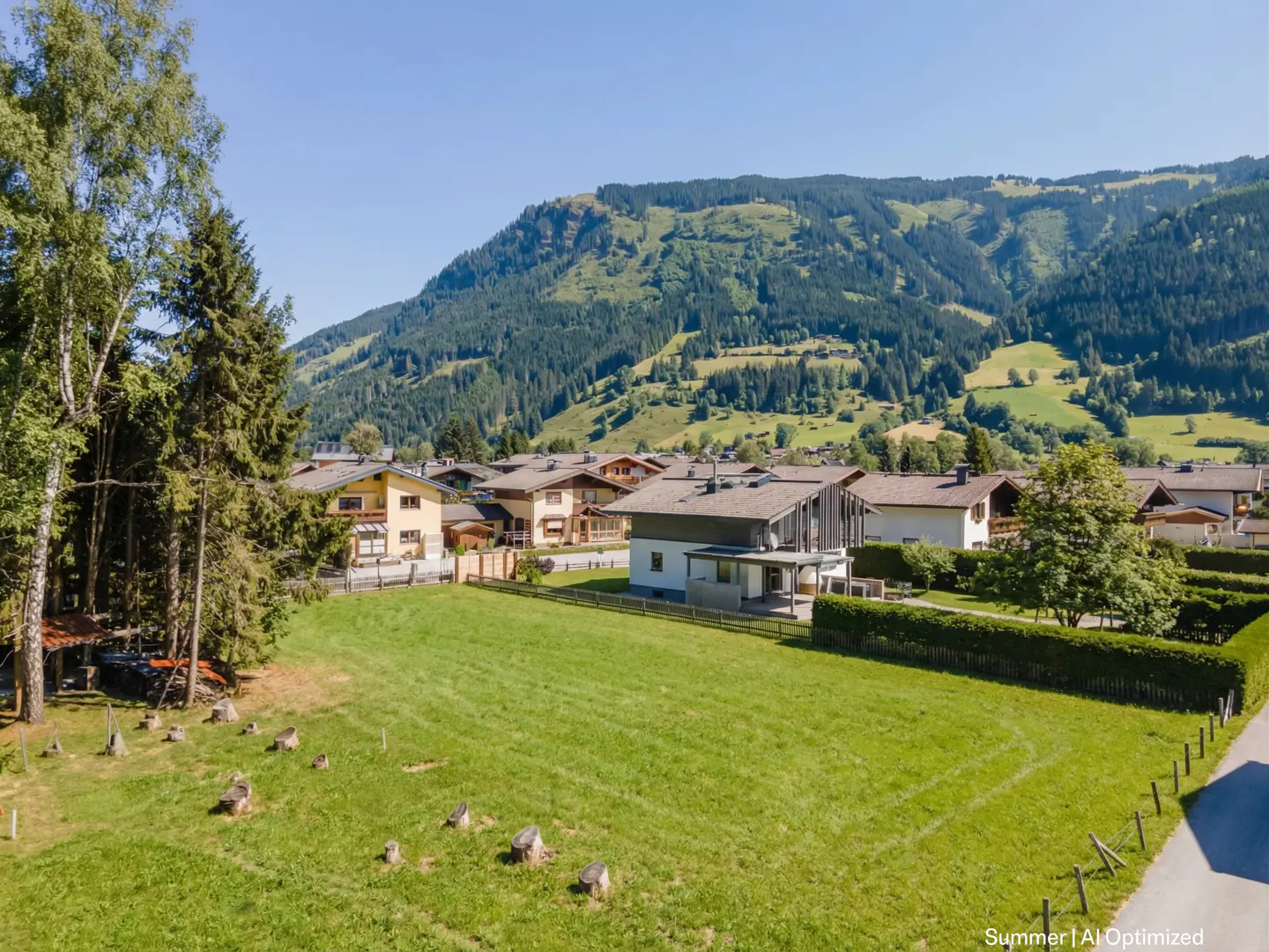 A scenic view of houses nestled in a valley with a lush green mountain backdrop.