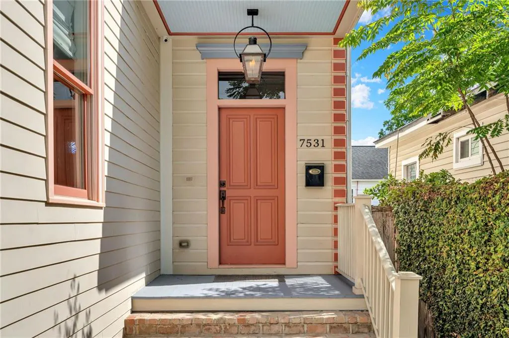 Front exterior of a house with a salmon-colored door, black mailbox, and the number 7531 above it.