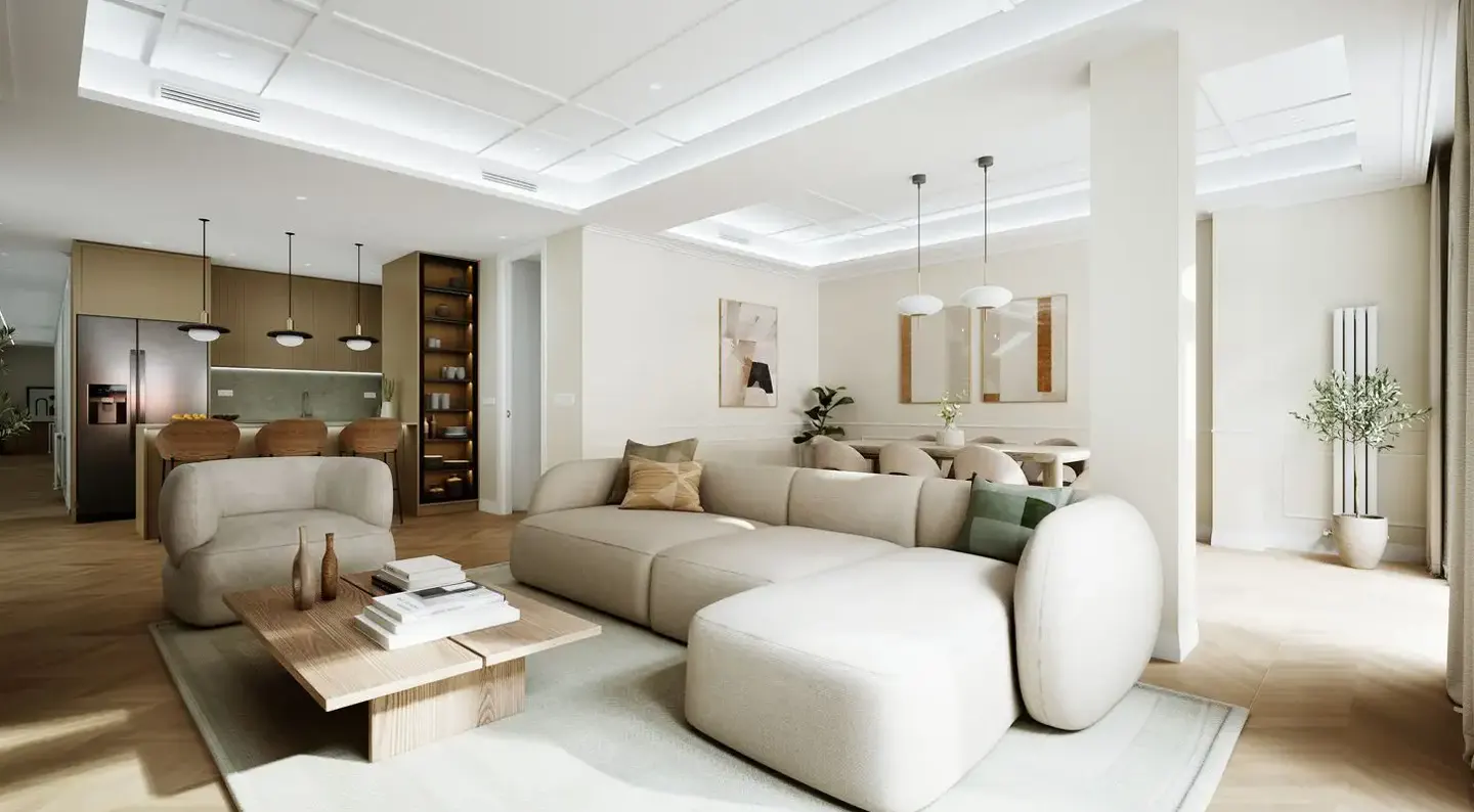 Bright, open-concept living space with a beige sectional sofa, wood coffee table, and kitchen island with bar stools in the background.