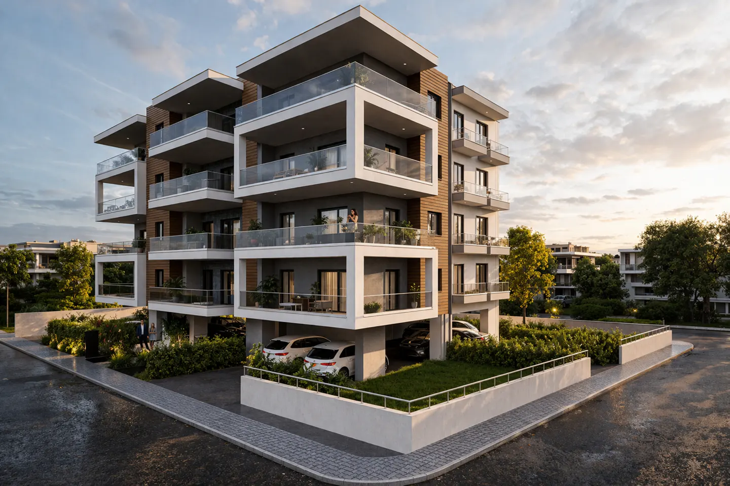 Modern apartment building with white balconies and wood accents. Cars are parked below, and greenery surrounds the building.