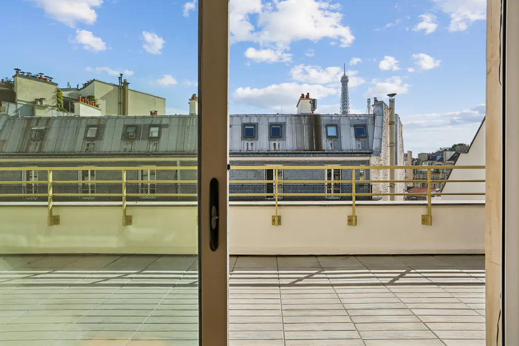 View from a balcony in Paris, France, with the Eiffel Tower visible in the distance.