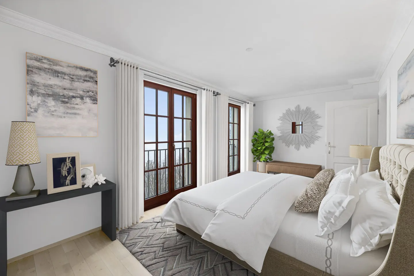 Bright bedroom with white walls, a large bed, and French doors leading to a balcony. A gray rug and console table add contrast.