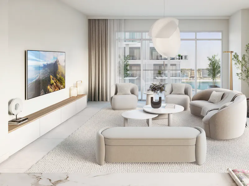 Bright living room with beige furniture, white walls, and a large TV displaying a mountain landscape. A window shows a city view.