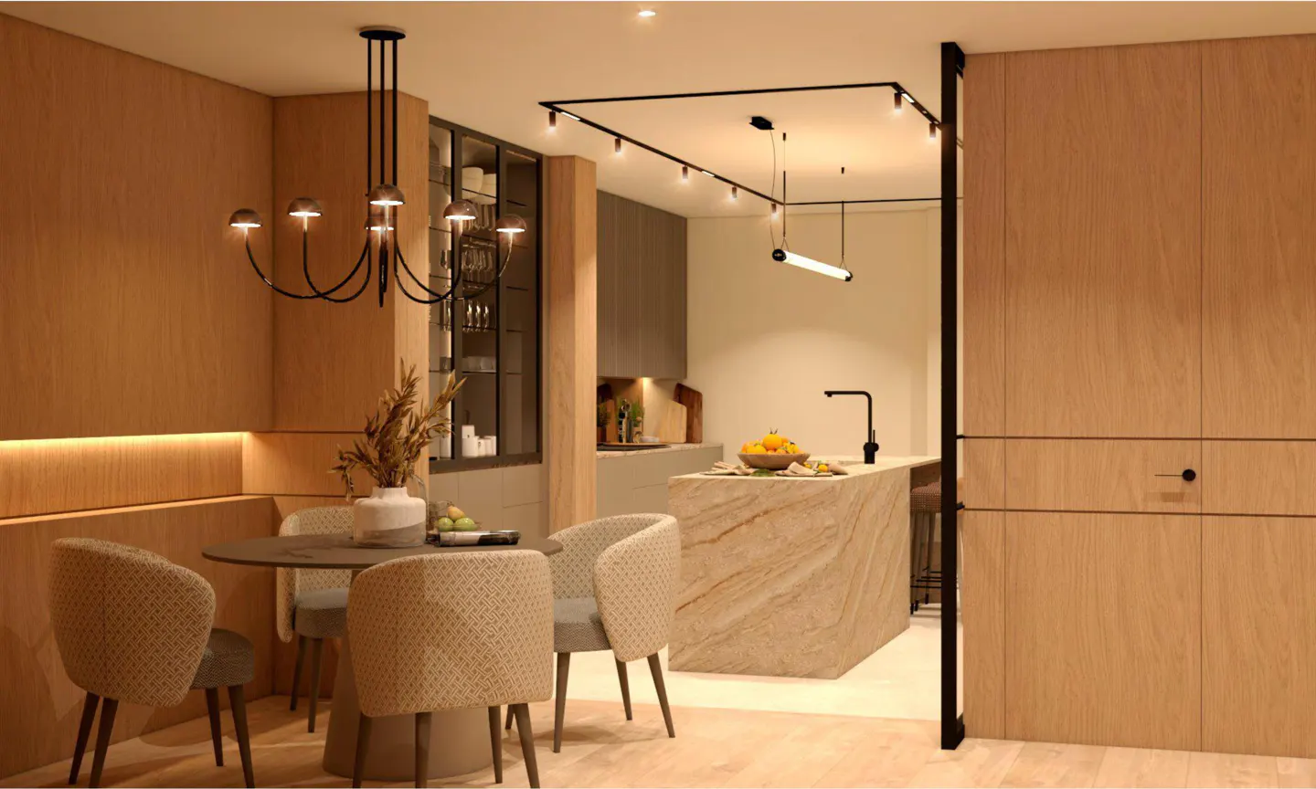 A modern dining area with a round table, chairs, and a black chandelier, leading into a kitchen with a marble island and track lighting.