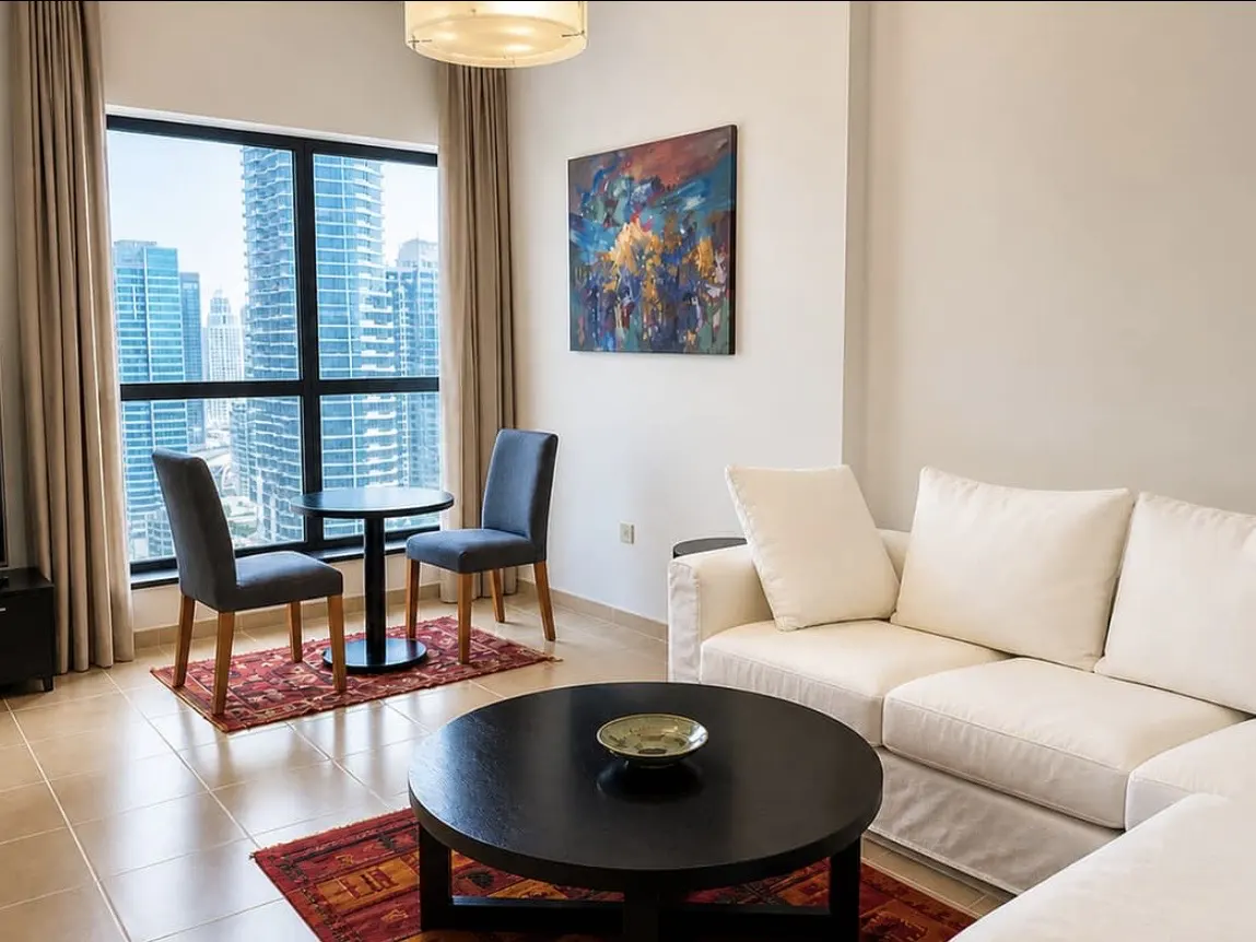 Living room with a white sofa, black coffee table, and a window view of city skyscrapers.