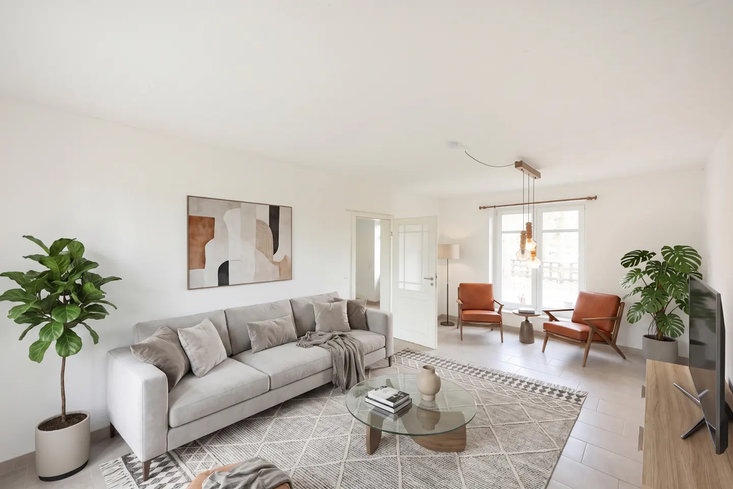Bright living room with a gray sofa, brown leather chairs, and a glass coffee table on a patterned rug. Abstract art hangs on the white wall.
