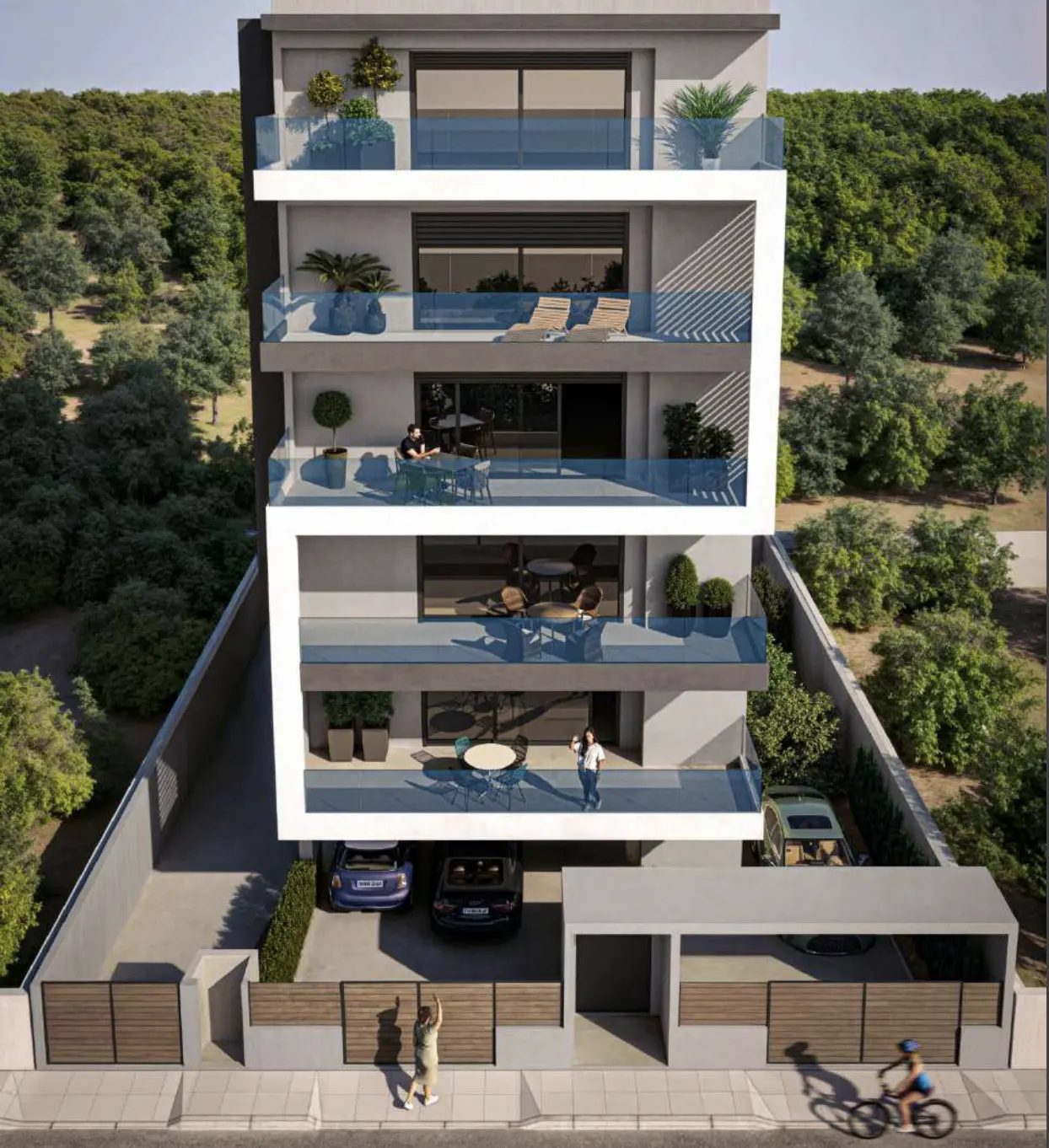 Modern four-story apartment building with balconies, cars parked below, and a wooded area in the background.