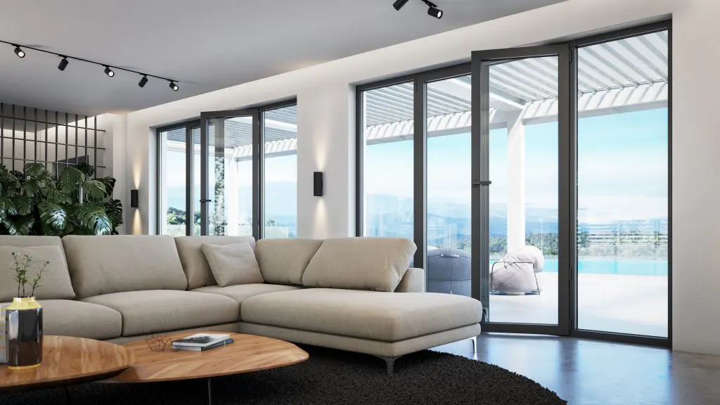 Modern living room with a beige sectional sofa, wood coffee tables, and black framed folding glass doors to a patio with a pool.