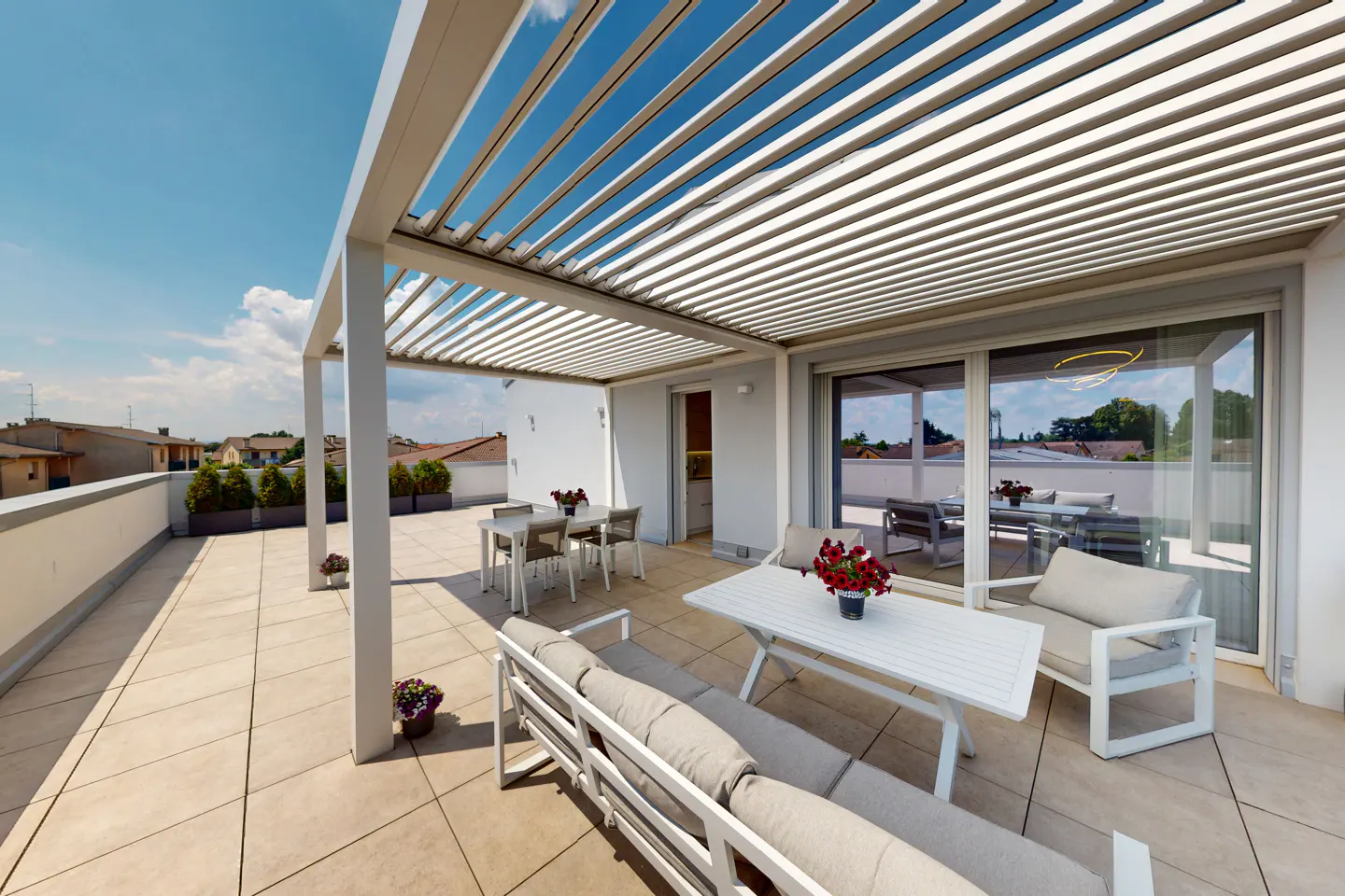 A rooftop patio with a white pergola, furniture, and a view of the city.