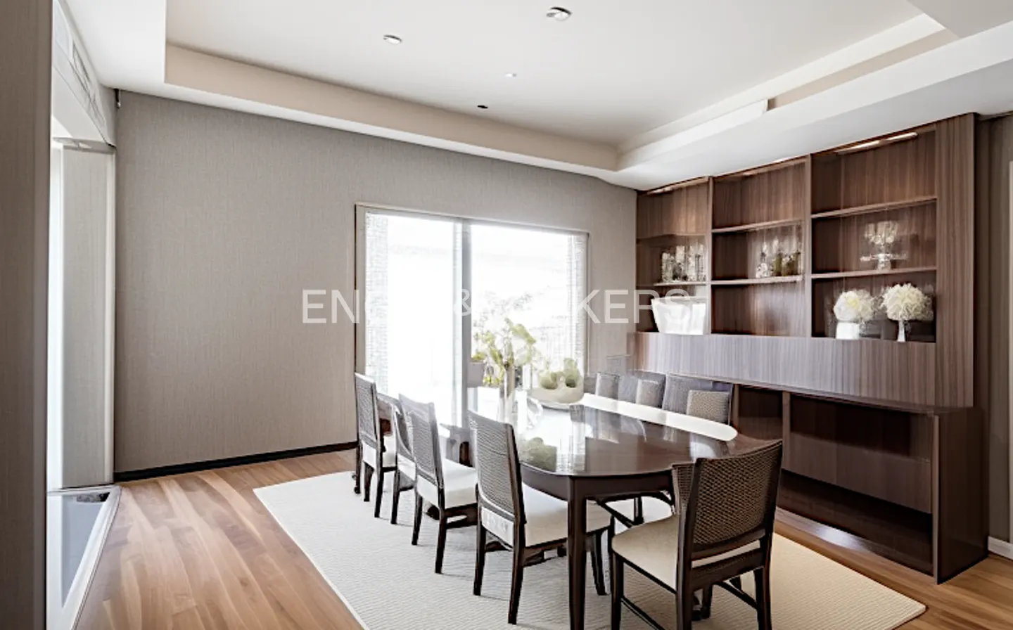 A dining room with a long, dark wood table and ten chairs on a white rug. A large window and a built-in wood cabinet are in the background.