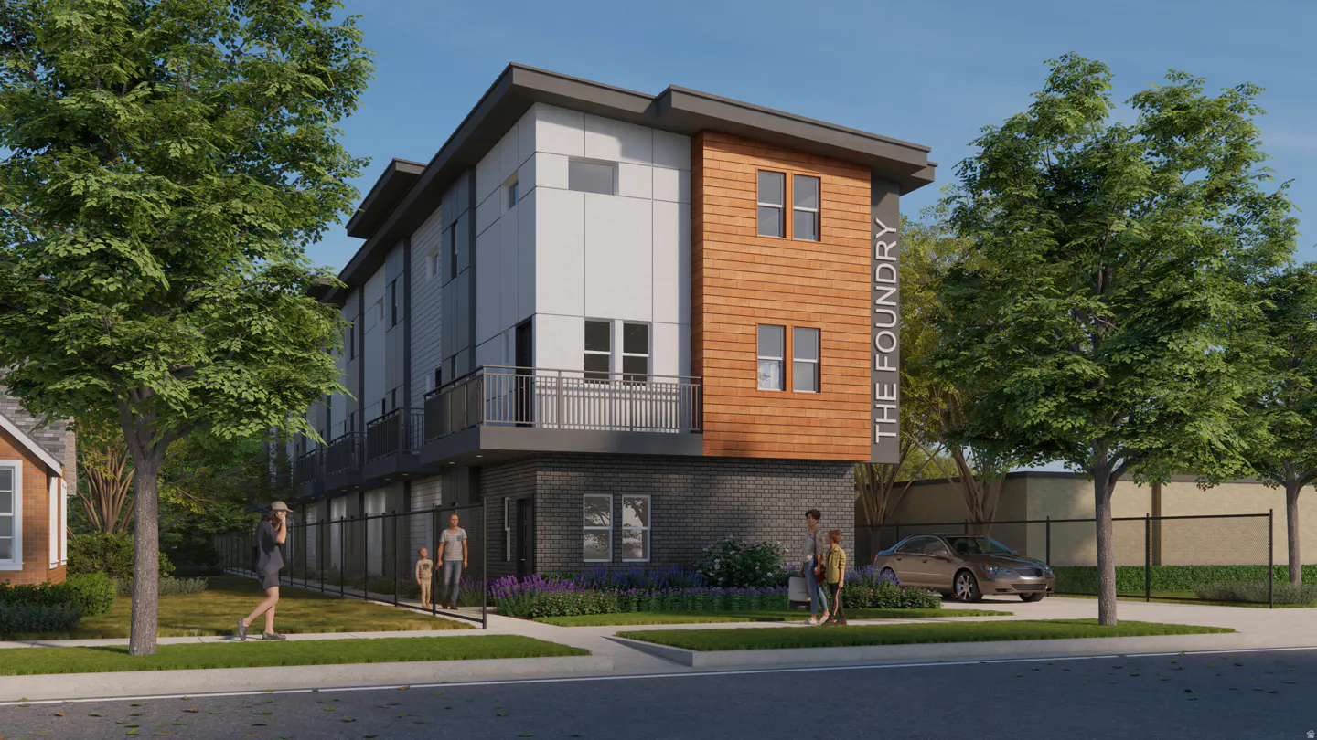 Modern townhouses with gray brick, white siding, and wood accents. "The Foundry" sign is visible. Trees and people are in the foreground.
