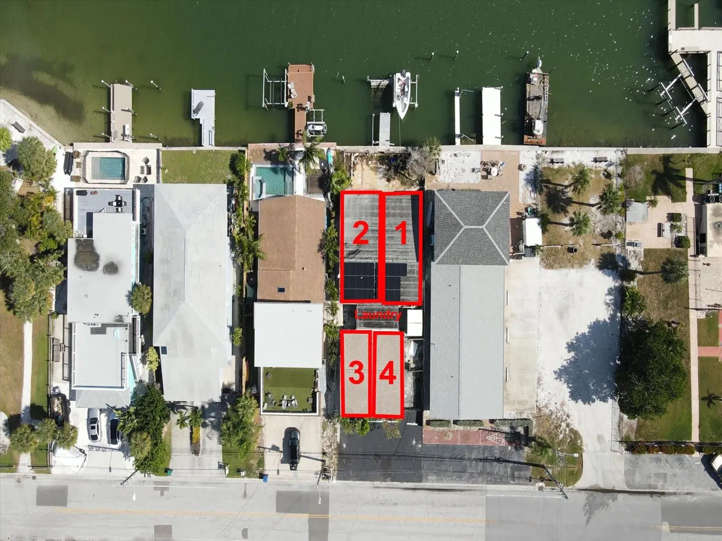 Aerial view of waterfront houses with docks, boats, and pools. Houses are numbered 1-4 in red.