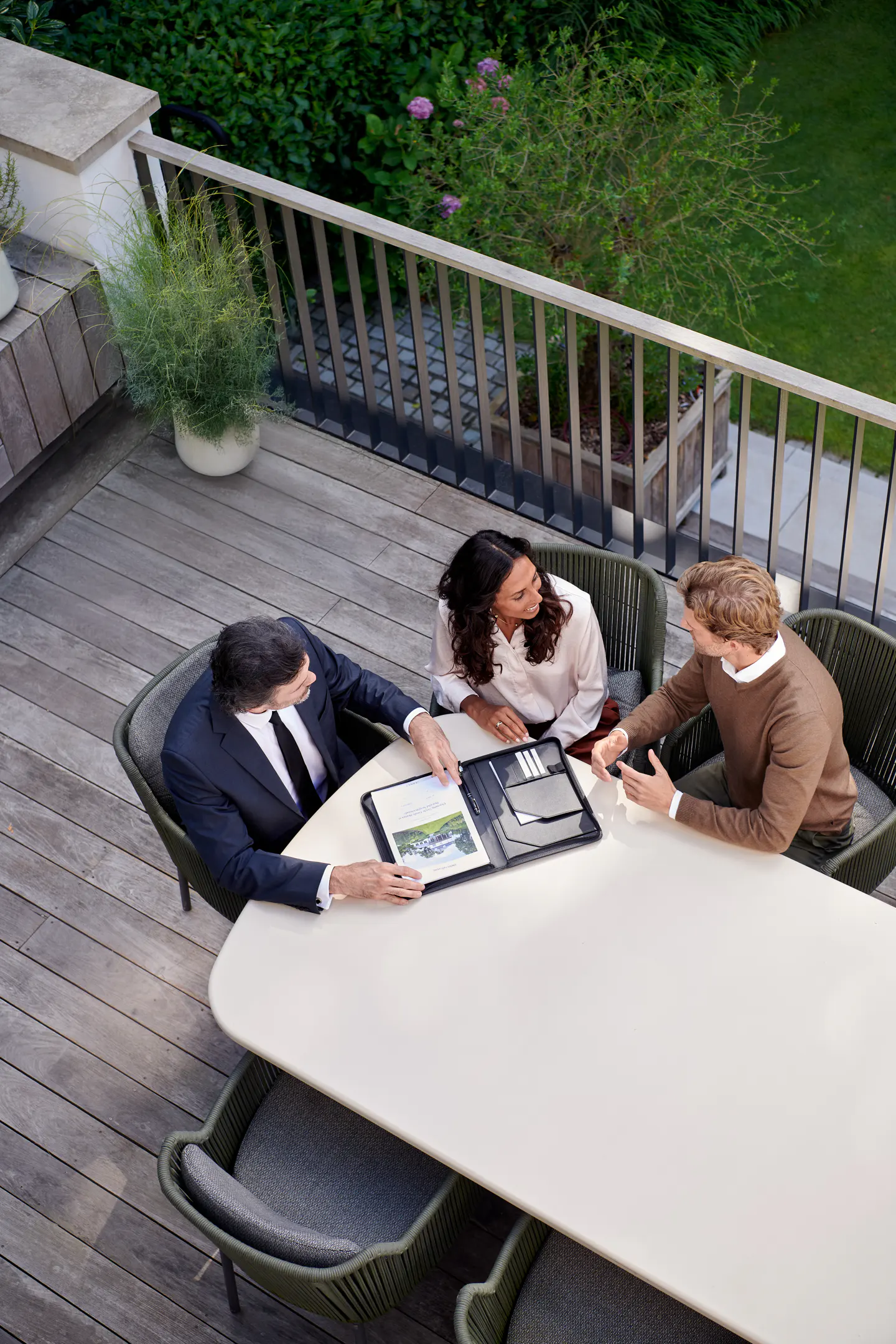 Real estate agent presenting property information to clients on a terrace
