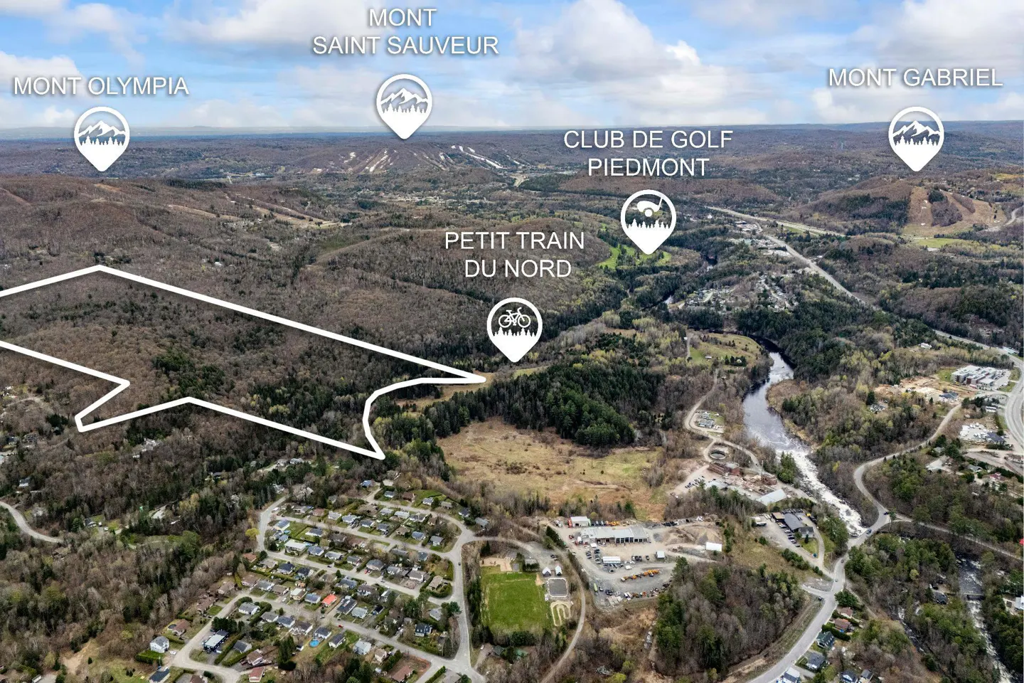 Aerial view of a wooded area with mountains in the distance, labeled with location icons.