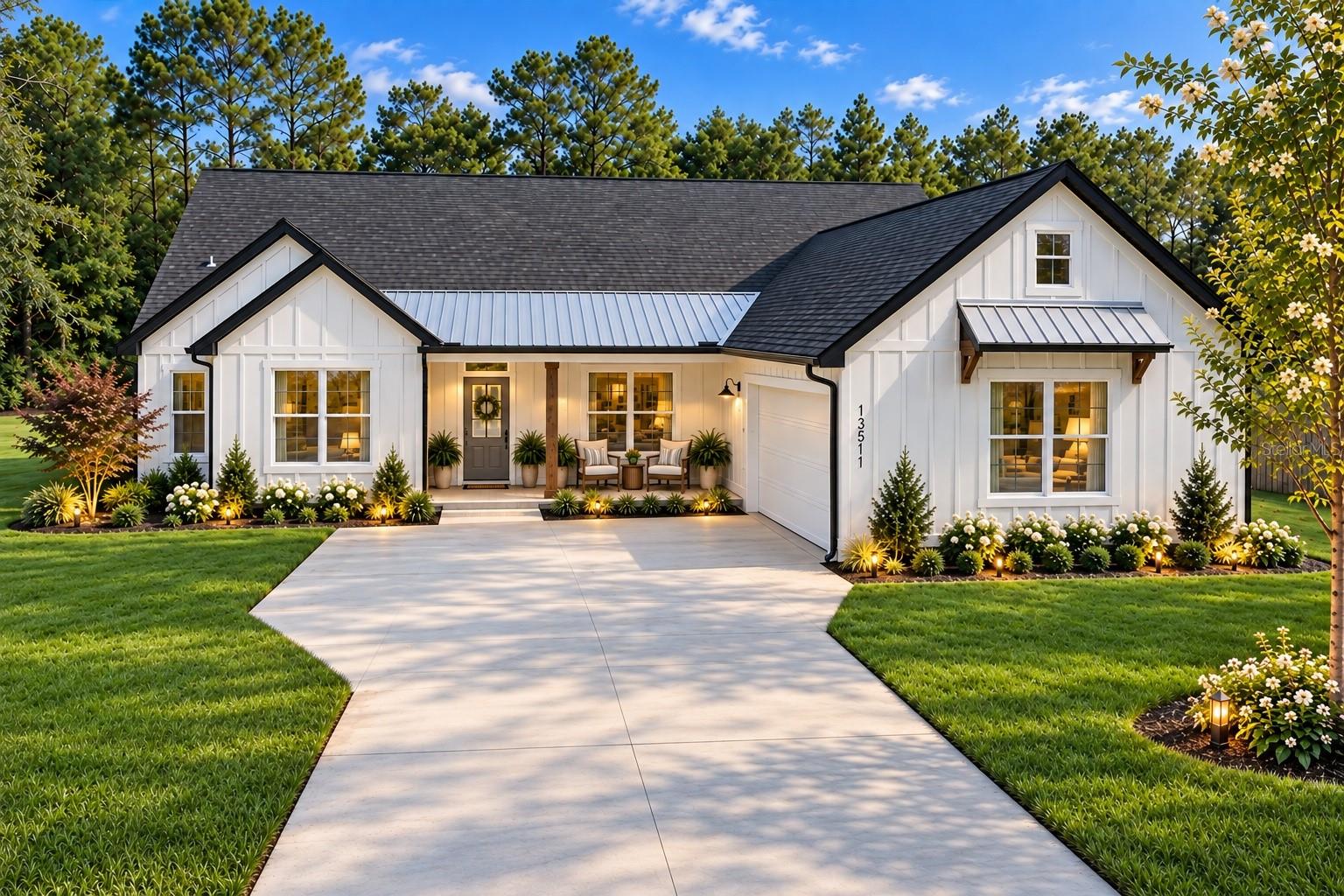 Modern white farmhouse with black roof, metal porch awning, concrete driveway, and manicured lawn against a forest backdrop. [AI-generated text]