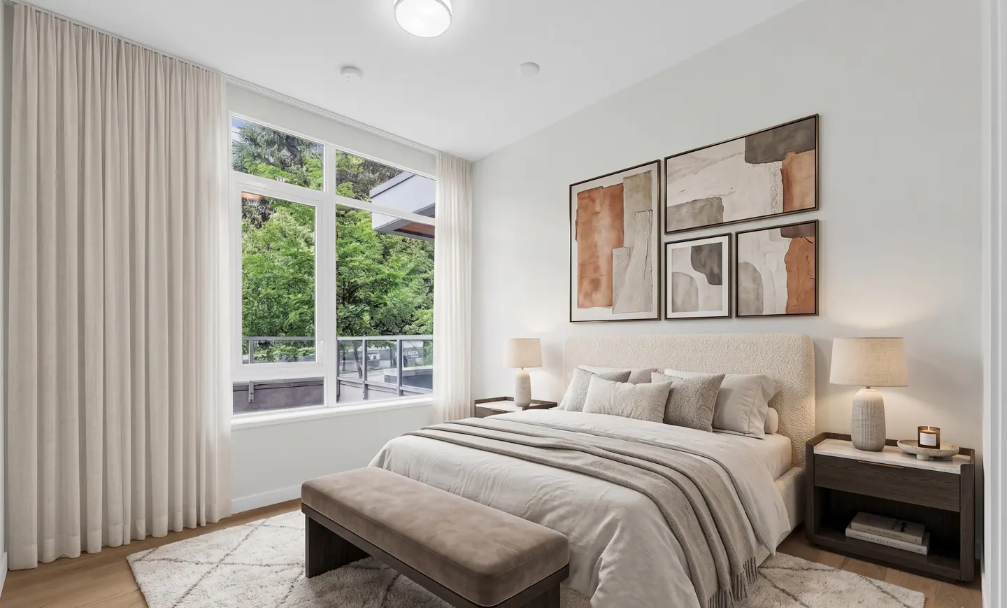 Bright bedroom with a large window showing green trees. A bed with neutral bedding, a bench, and abstract art complete the space.