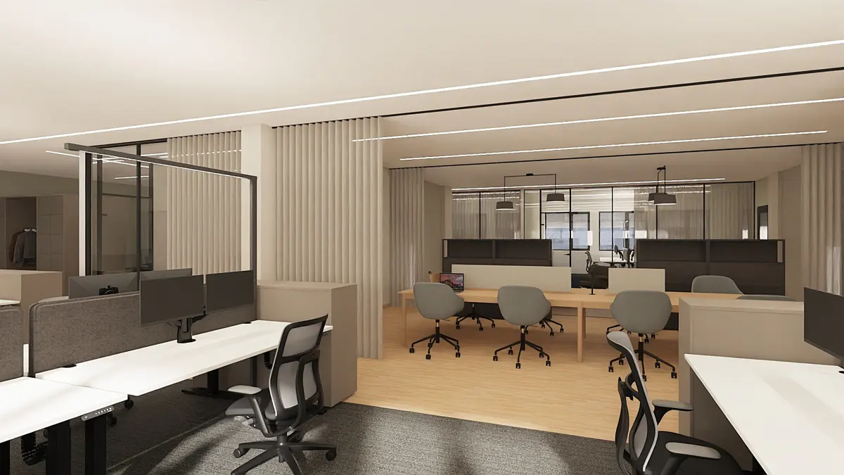 Open office space with white desks, gray chairs, and monitors. Glass partitions and wood floors create a modern, collaborative work environment.