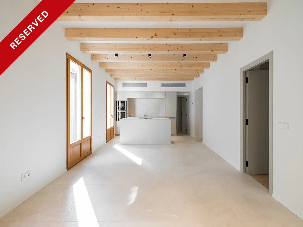 Bright, modern interior with white walls, wood beams, and a white kitchen island. A red "RESERVED" banner is in the upper left corner.
