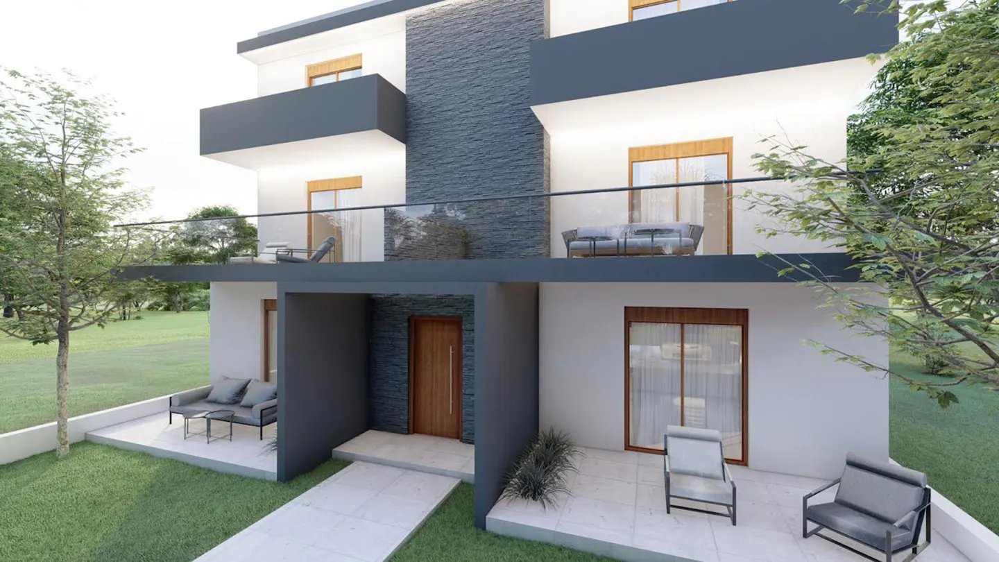 Modern two-story house with white walls, dark gray stone accents, balconies, and a patio area with outdoor furniture.