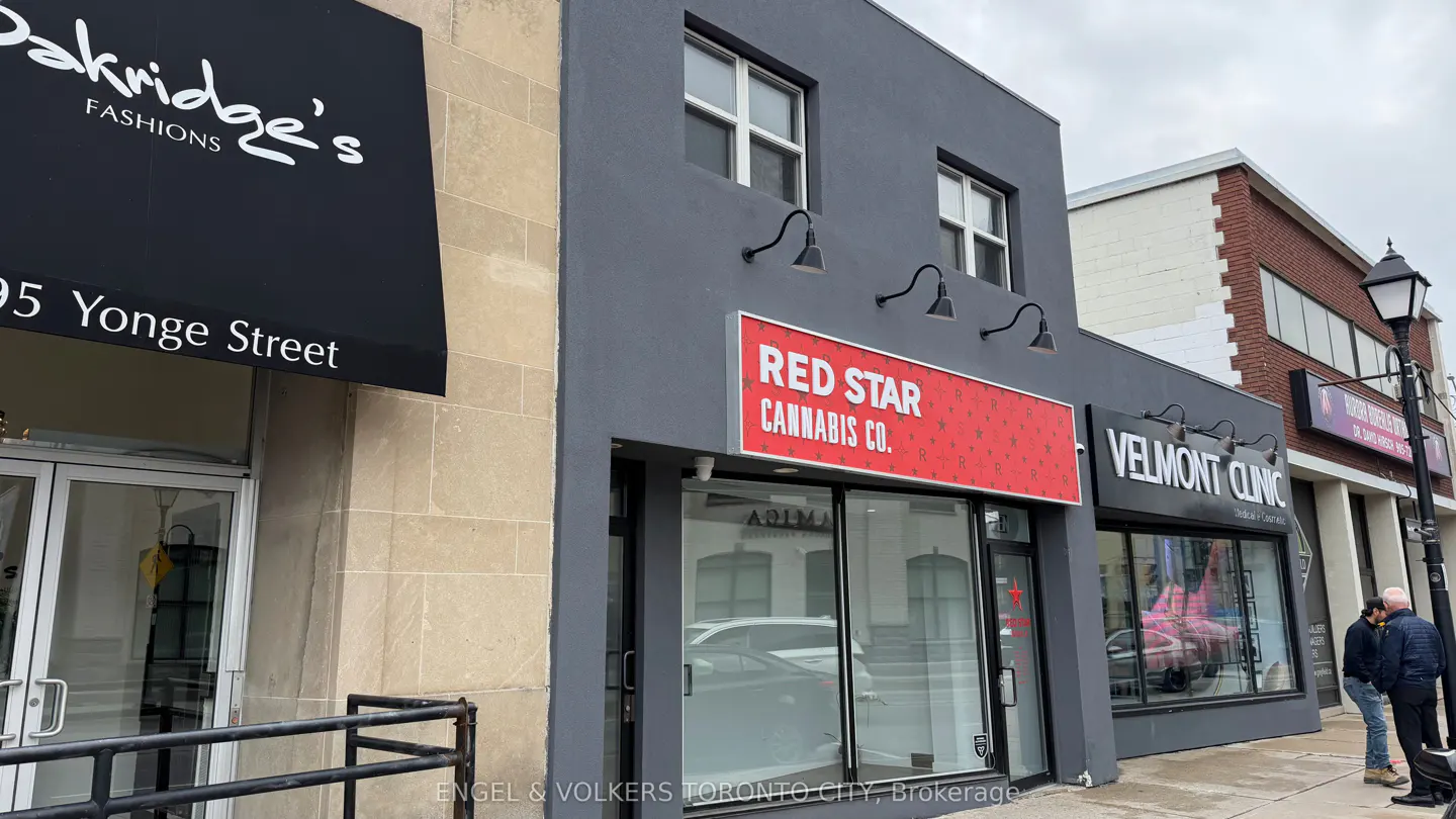 Street view of commercial buildings, including "Red Star Cannabis Co." with a red sign, and "Velmont Clinic" with people outside.