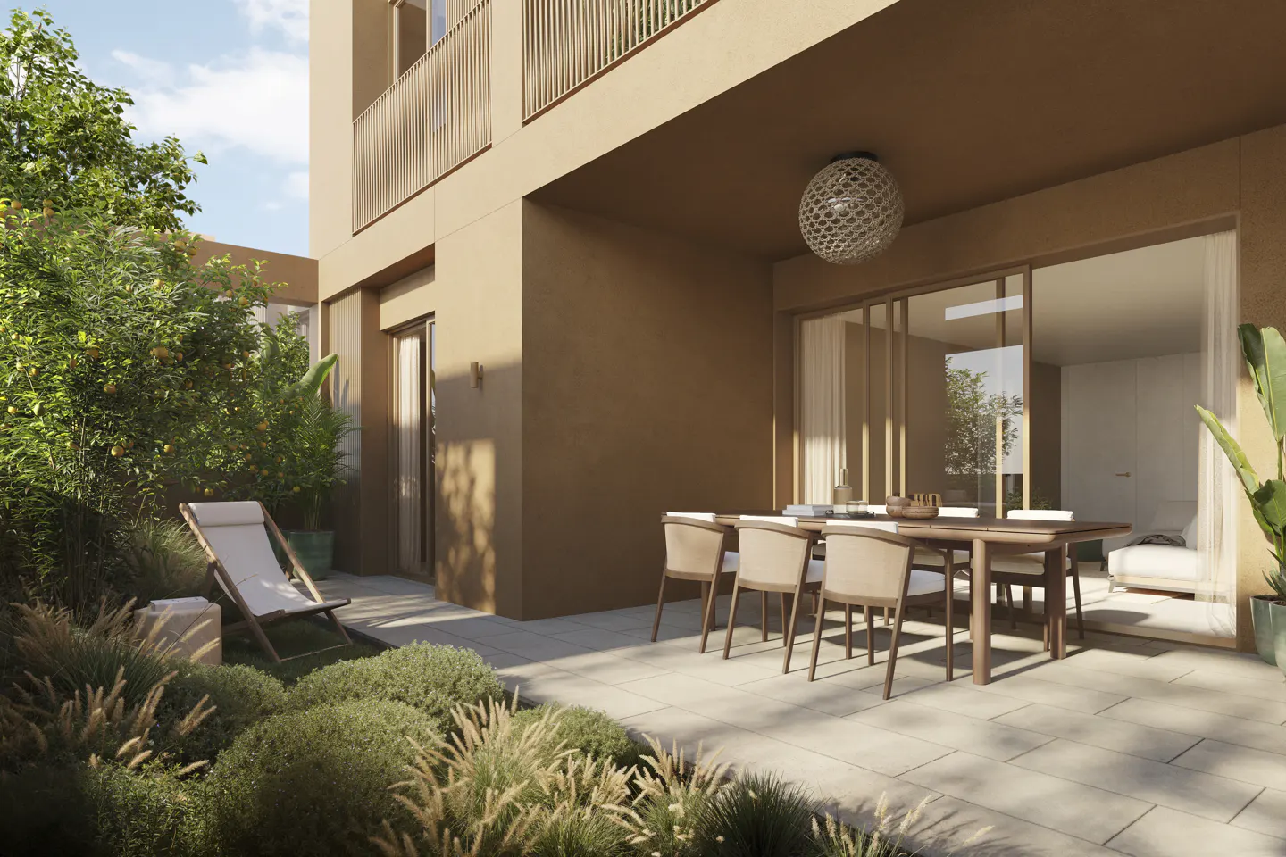 Modern patio with a dining set, lounge chair, and lush garden plants against a tan building exterior.