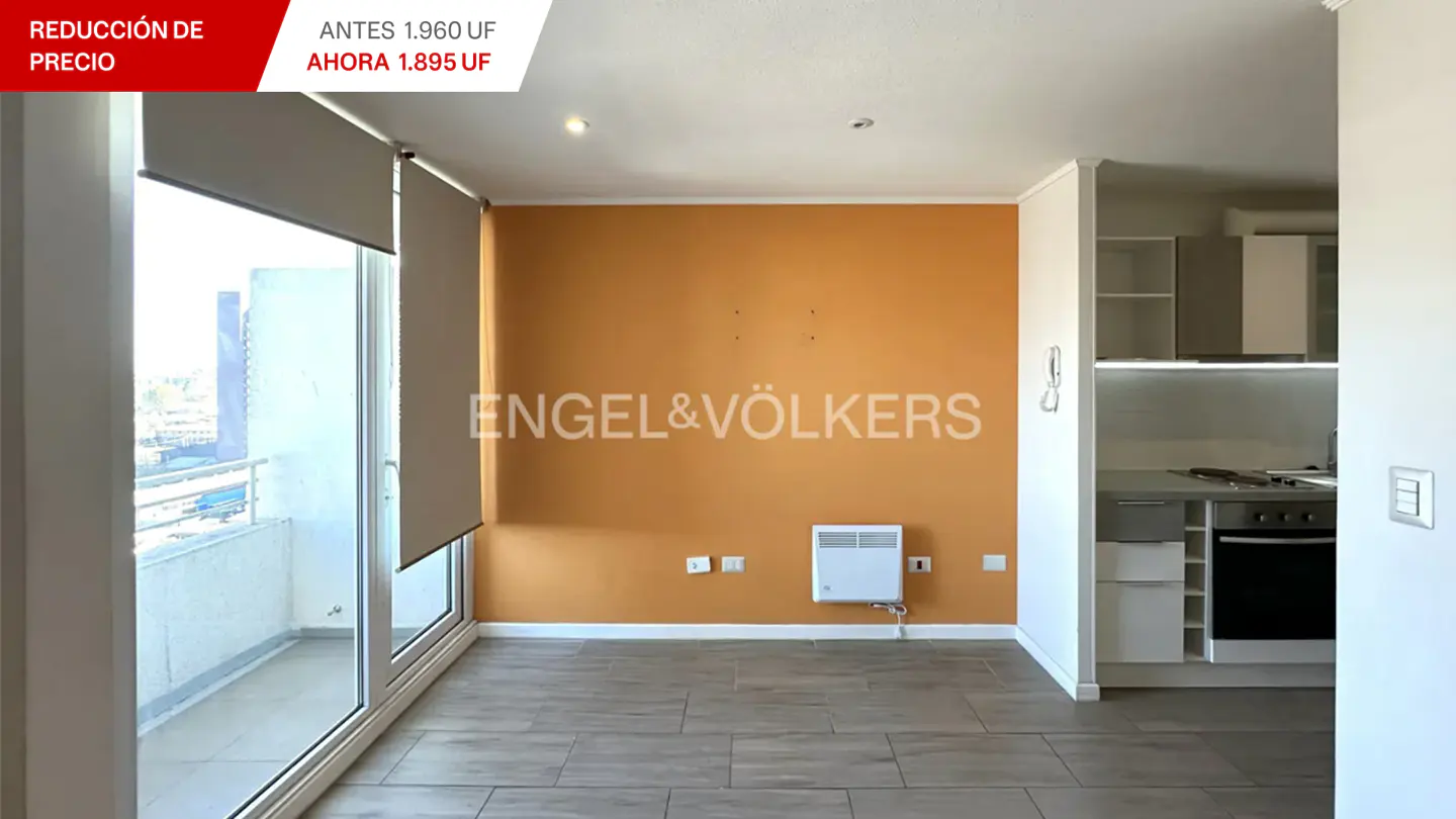 Bright apartment interior with orange accent wall, light wood floors, and a view from the balcony. Engel & Völkers logo on the wall.