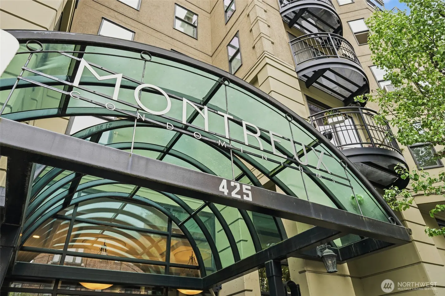 Exterior shot of the Montreux Condominiums building entrance with a glass awning and the address number 425.