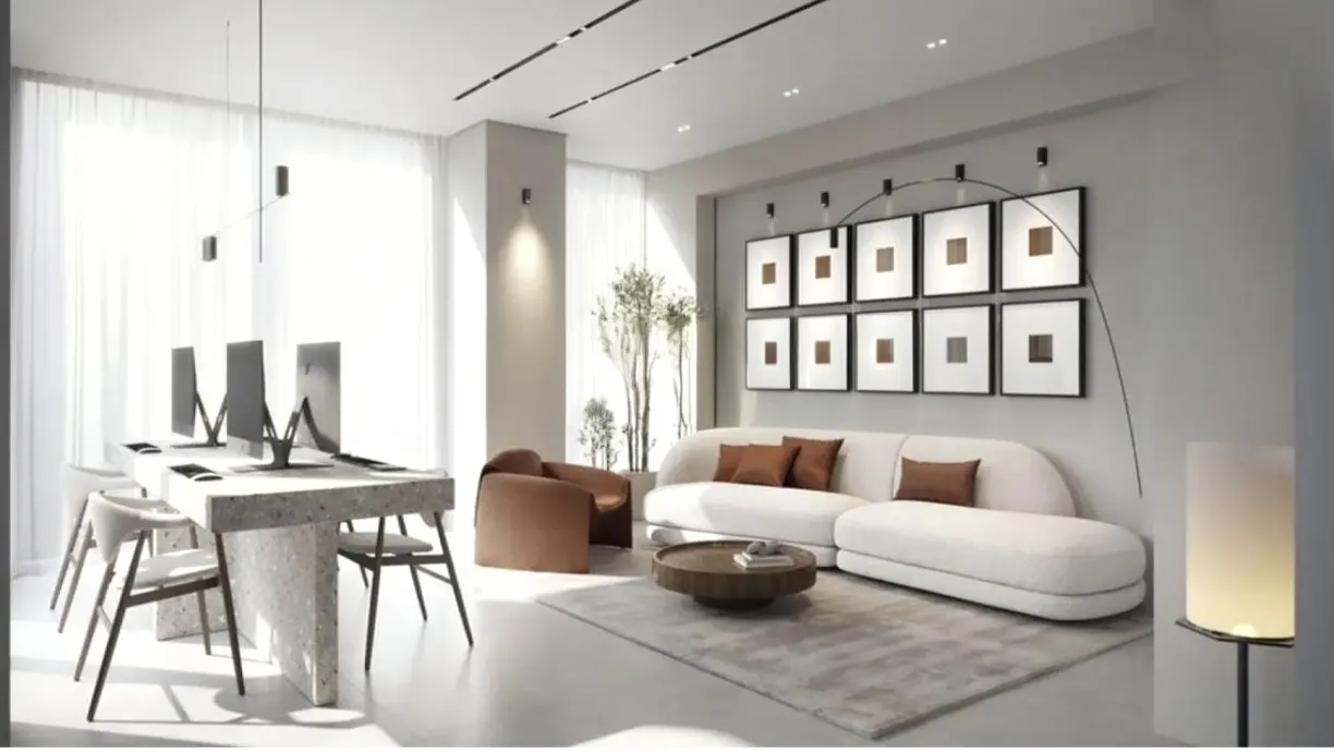 Bright, modern living space with a white sofa, brown accents, and a desk with computers by a window. Artwork adorns the wall.