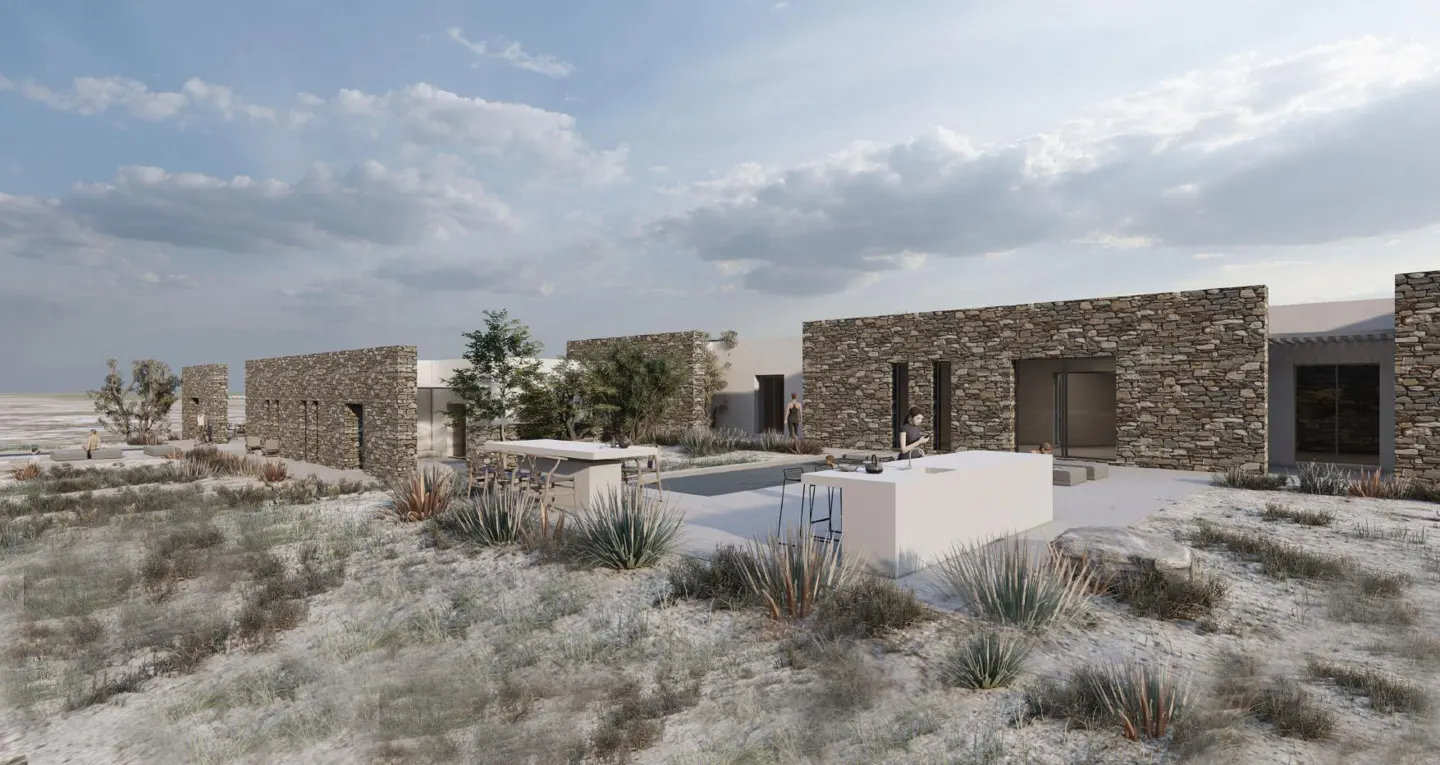 Exterior view of a stone house with a pool, white bar, and desert landscaping under a cloudy sky.