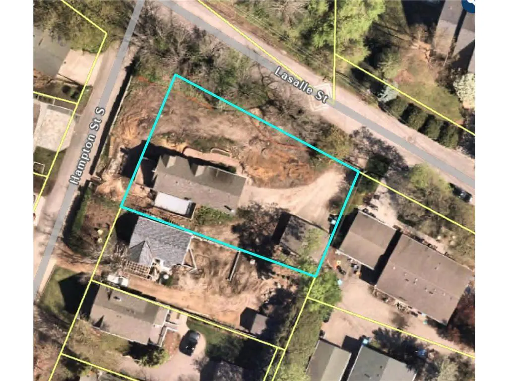 Aerial view of a property outlined in blue, showing a house, yard, and surrounding neighborhood streets.