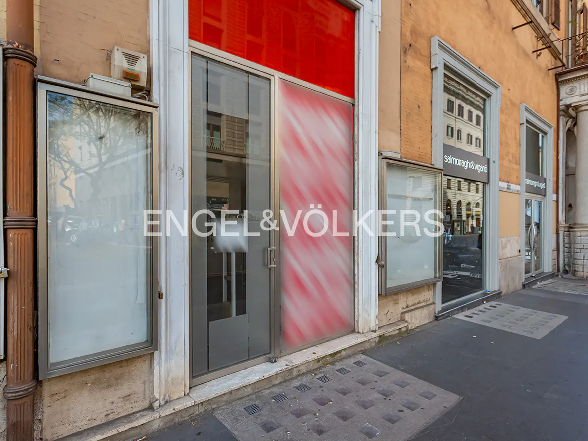 Exterior view of Engel & Völkers real estate office with glass doors and windows on a city street.