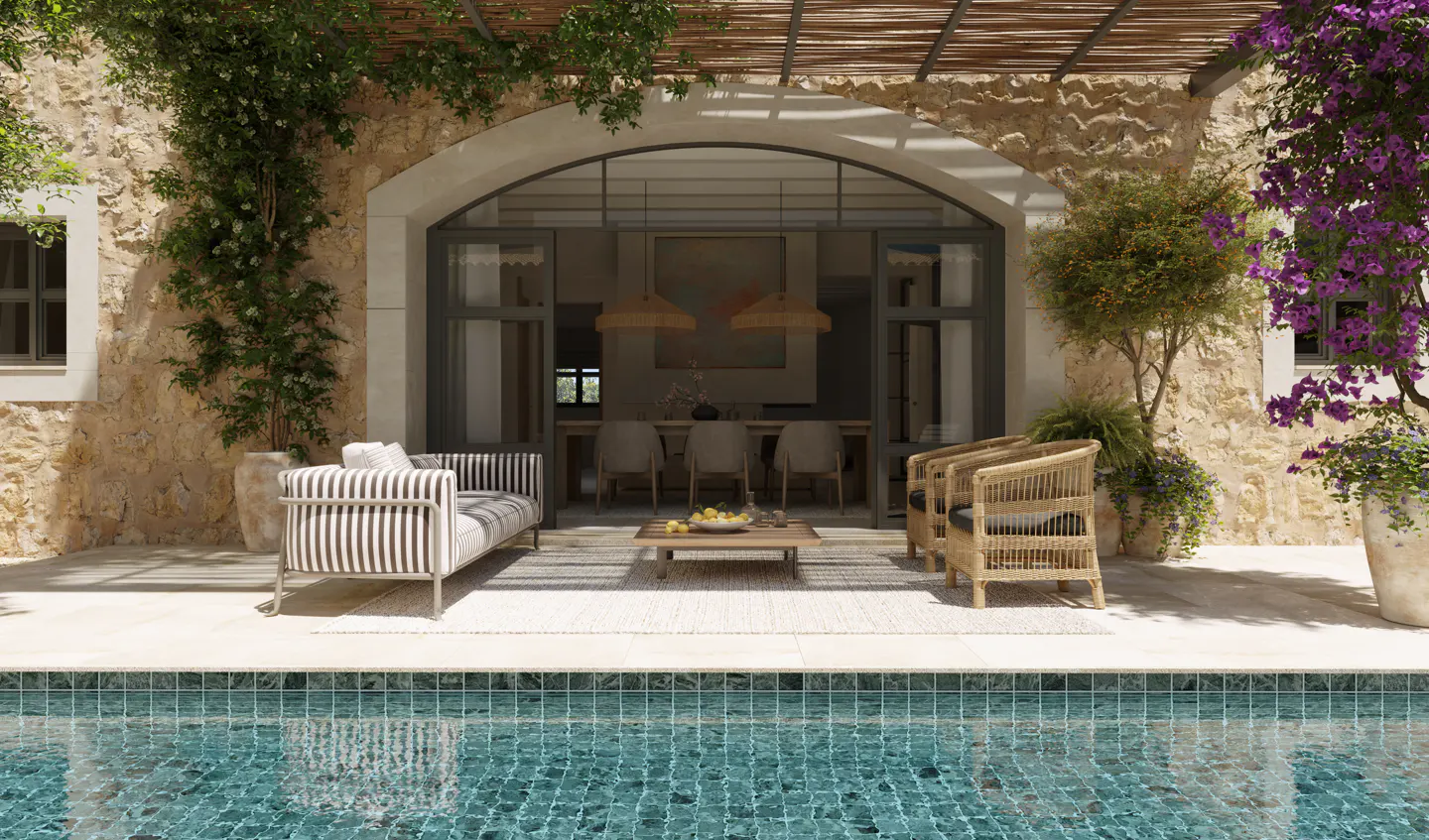 Outdoor patio with pool, stone walls, and arched doorway. Striped sofa, wicker chairs, and a wooden table with lemons.