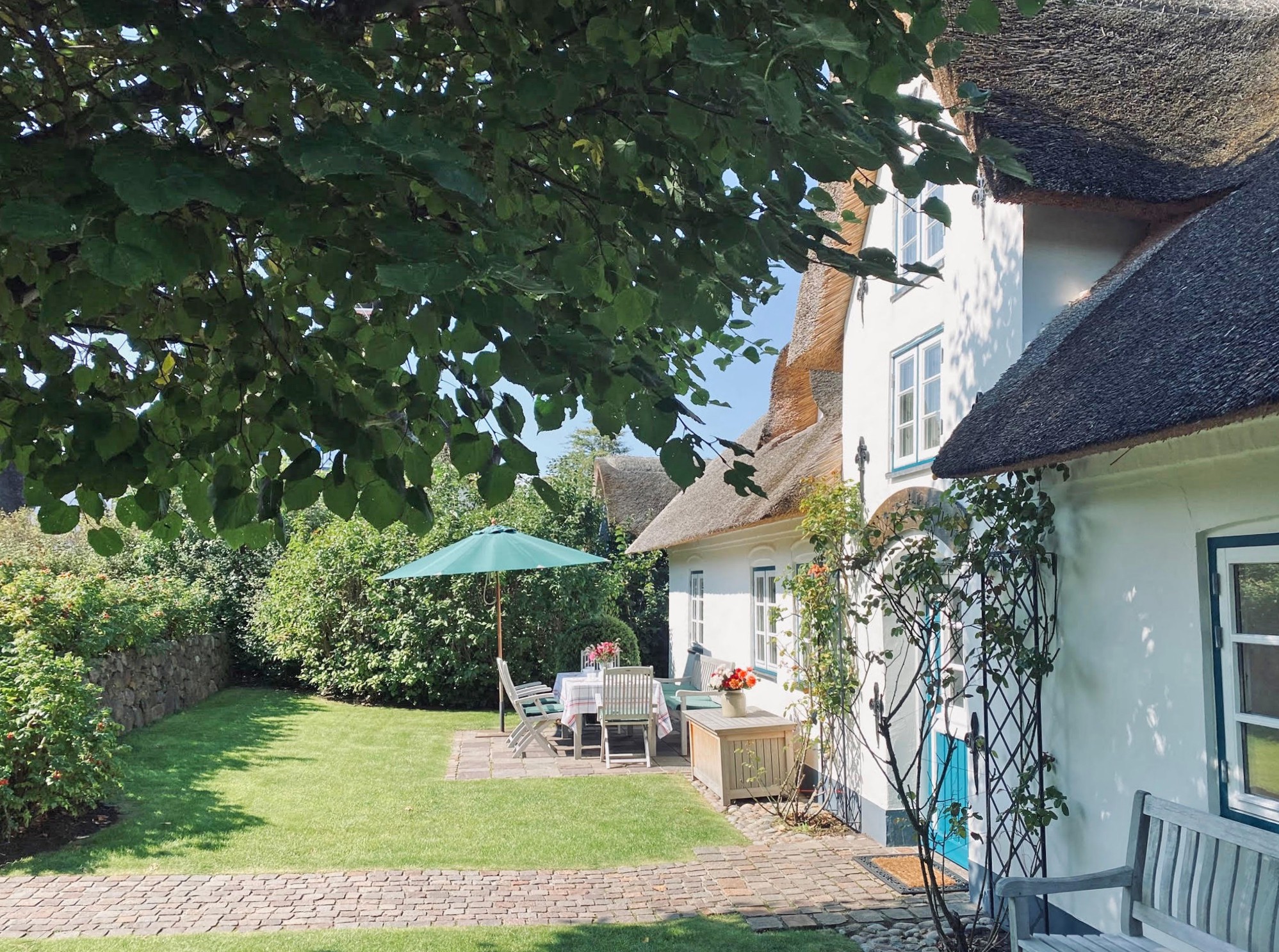reetgedecktes Friesenhaus in historischer Umgebung