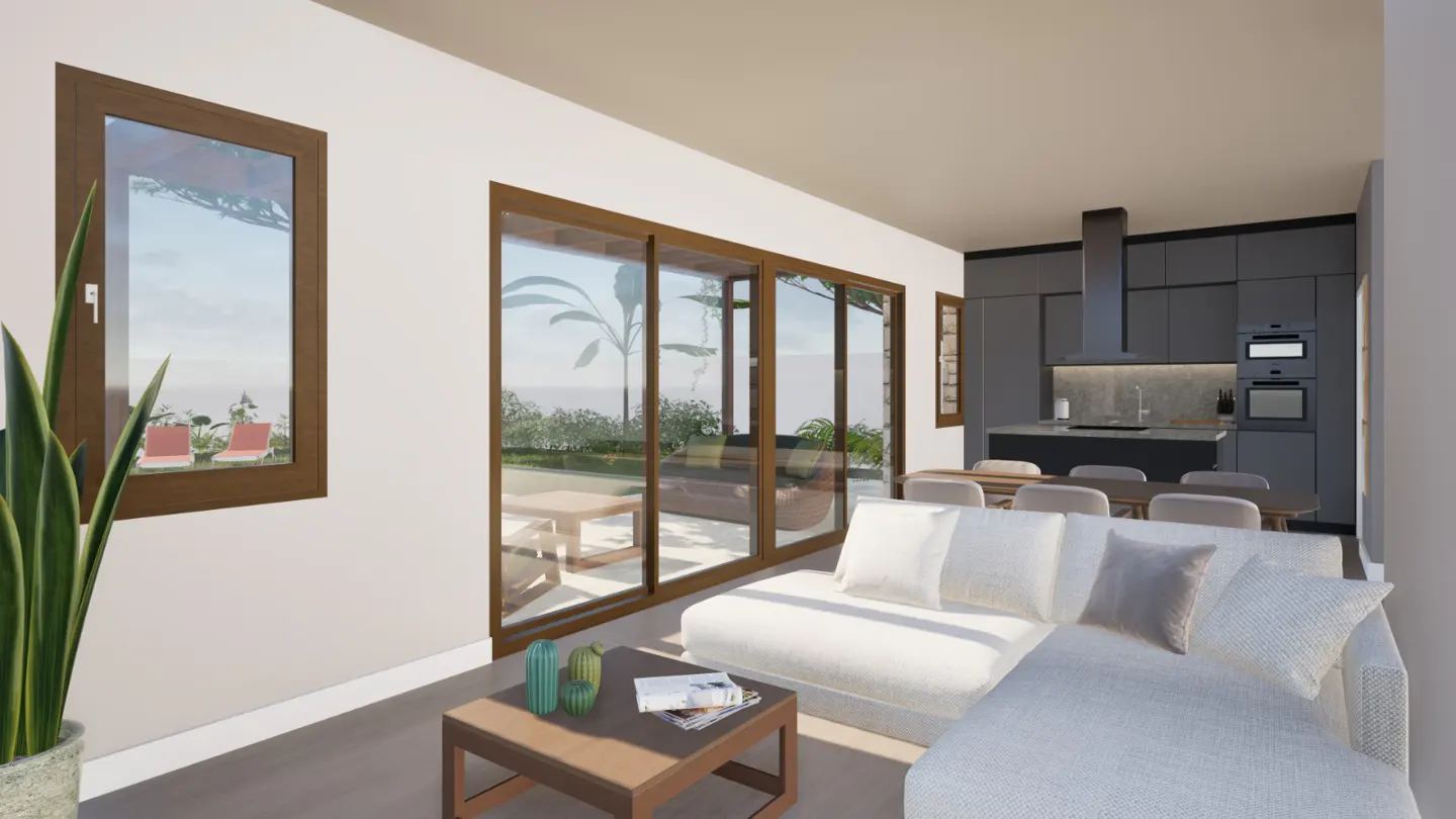 A modern living room with a white sectional sofa, a brown coffee table, and a view of the ocean through large windows. The kitchen is in the background.