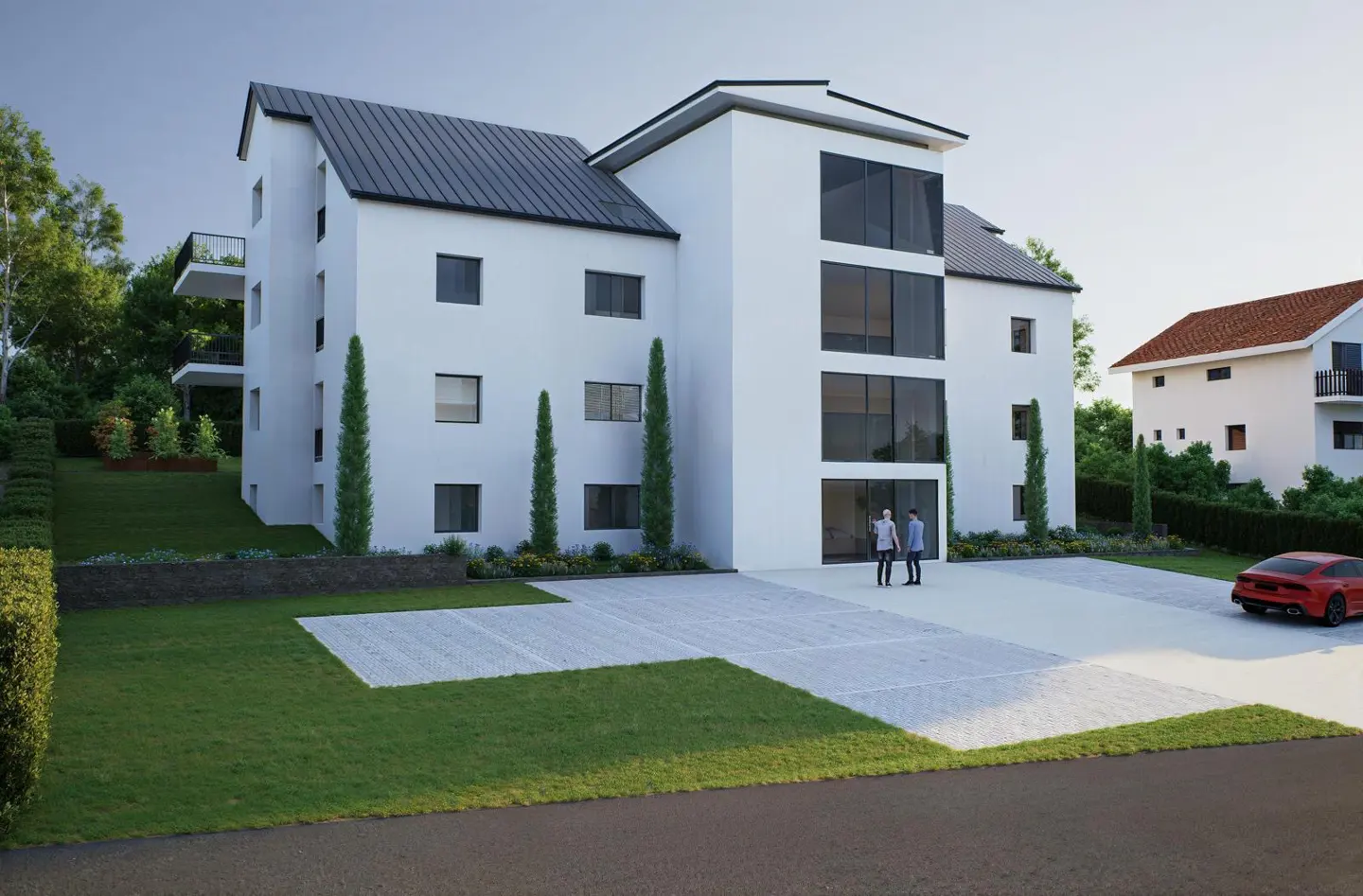 Modern white apartment building with black roof, large windows, and parking. Two people stand near the entrance, and a red car is parked nearby.