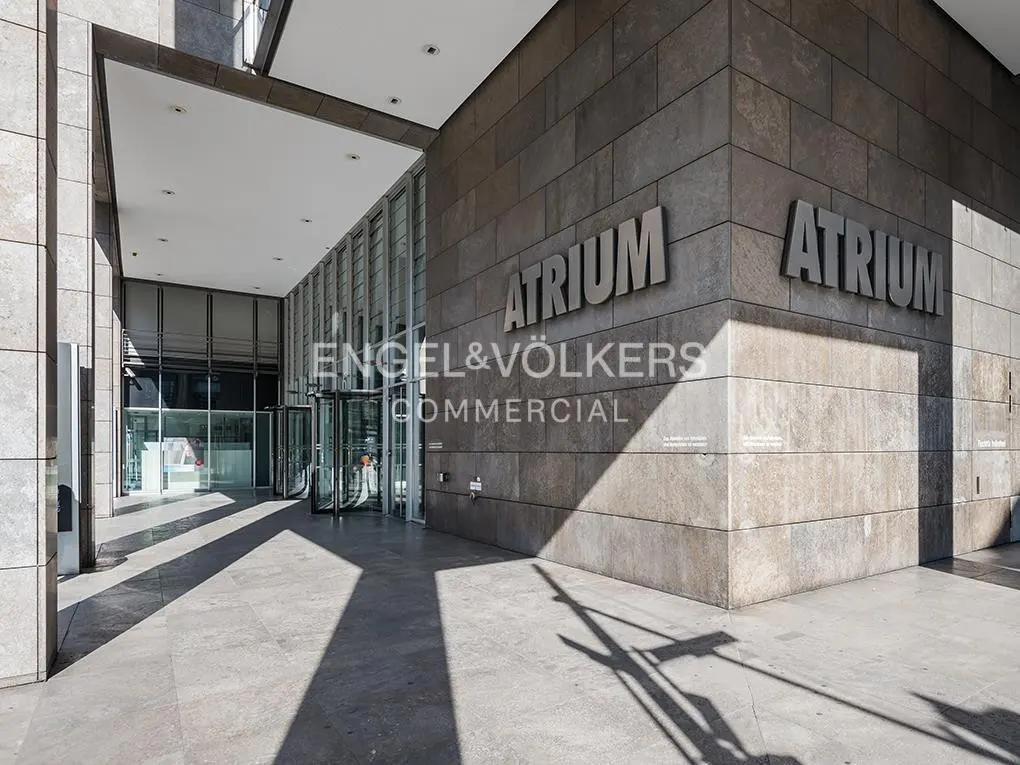 Exterior view of the Atrium building with Engel & Völkers Commercial signage. Revolving doors lead into the modern office space.