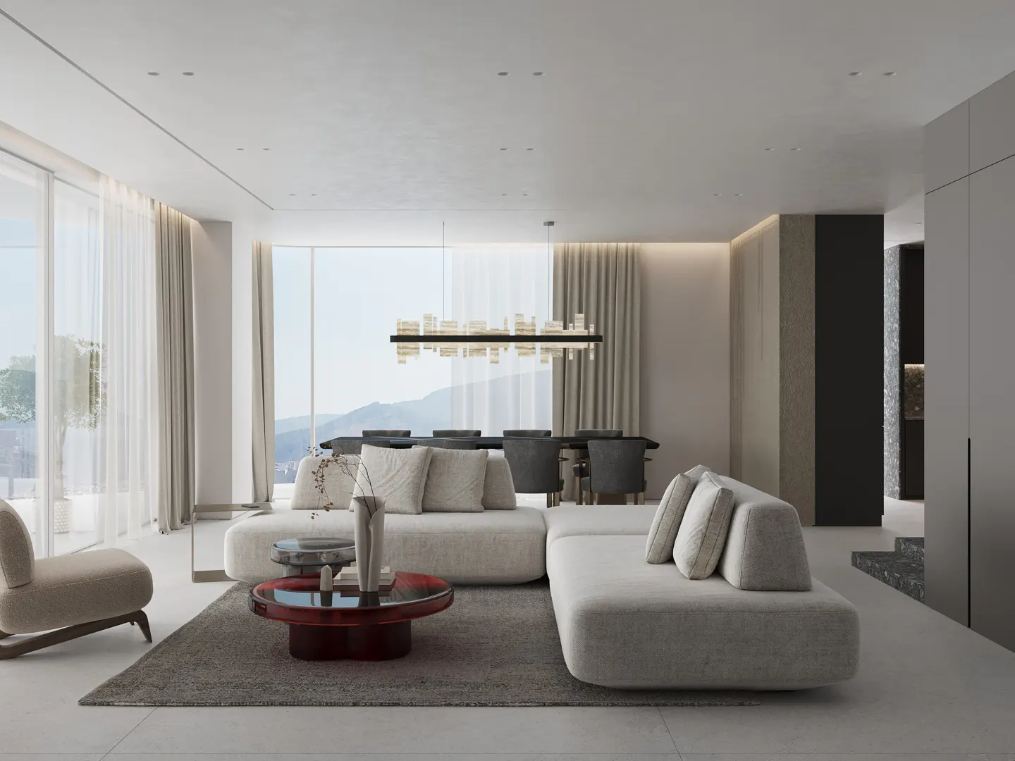 Bright, modern living room with a white sectional sofa, red coffee table, and large windows with mountain views.