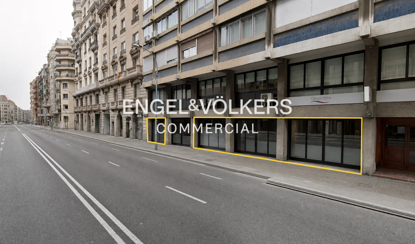 Engel & Völkers commercial property with a yellow border on a city street. The building has large windows and is next to a busy road.